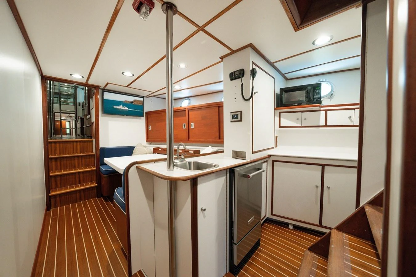 The yacht's galley features modern appliances and a cozy dining area with wooden accents. aboard PASSAGE Yacht for Sale