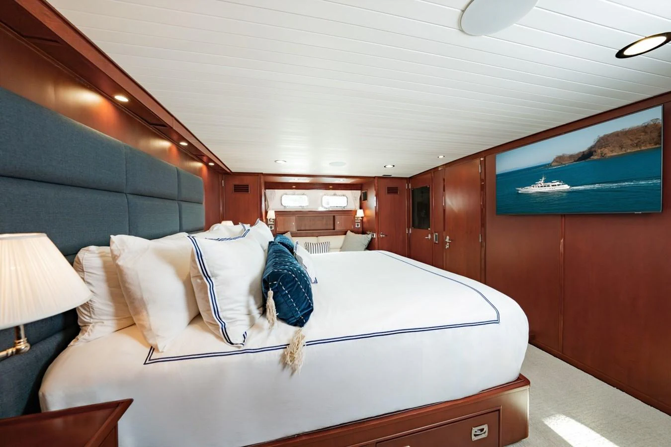 The master stateroom features a luxurious bed with elegant bedding and a flat-screen TV. aboard PASSAGE Yacht for Sale