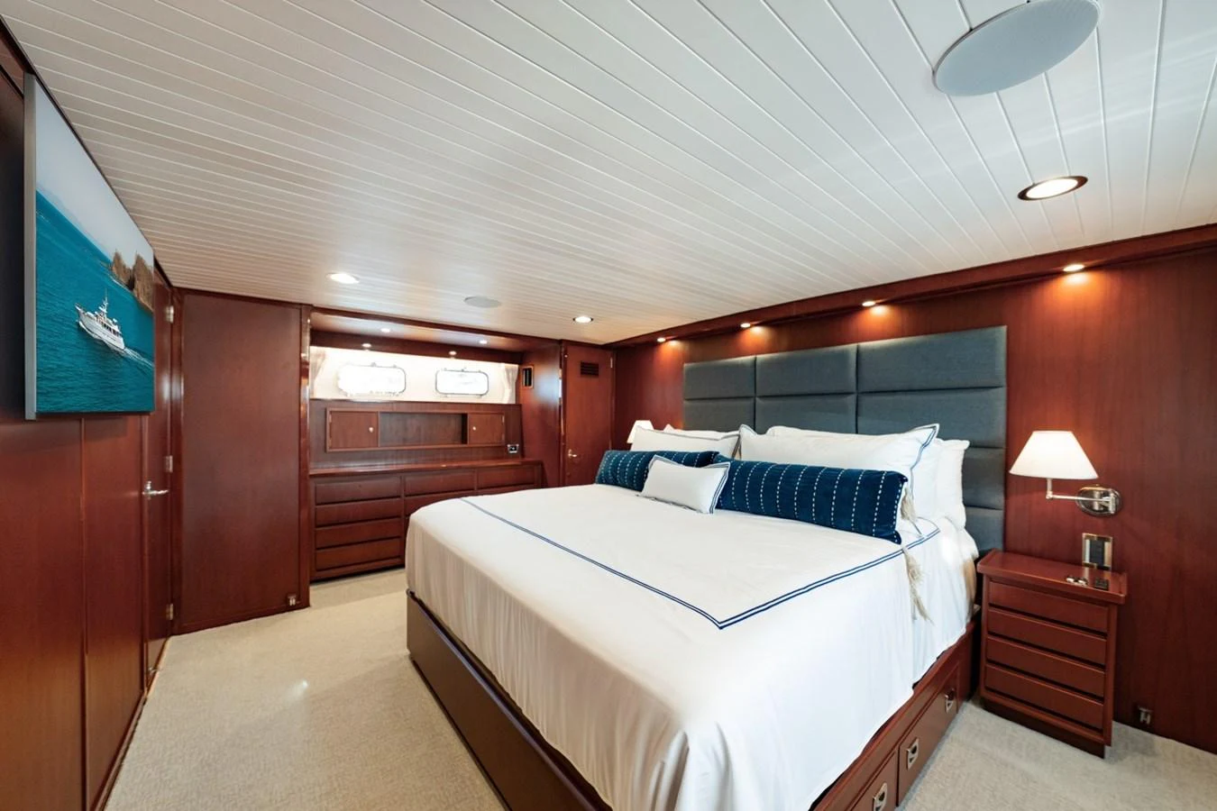 The master stateroom features a spacious bed with elegant wood paneling and modern lighting. aboard PASSAGE Yacht for Sale