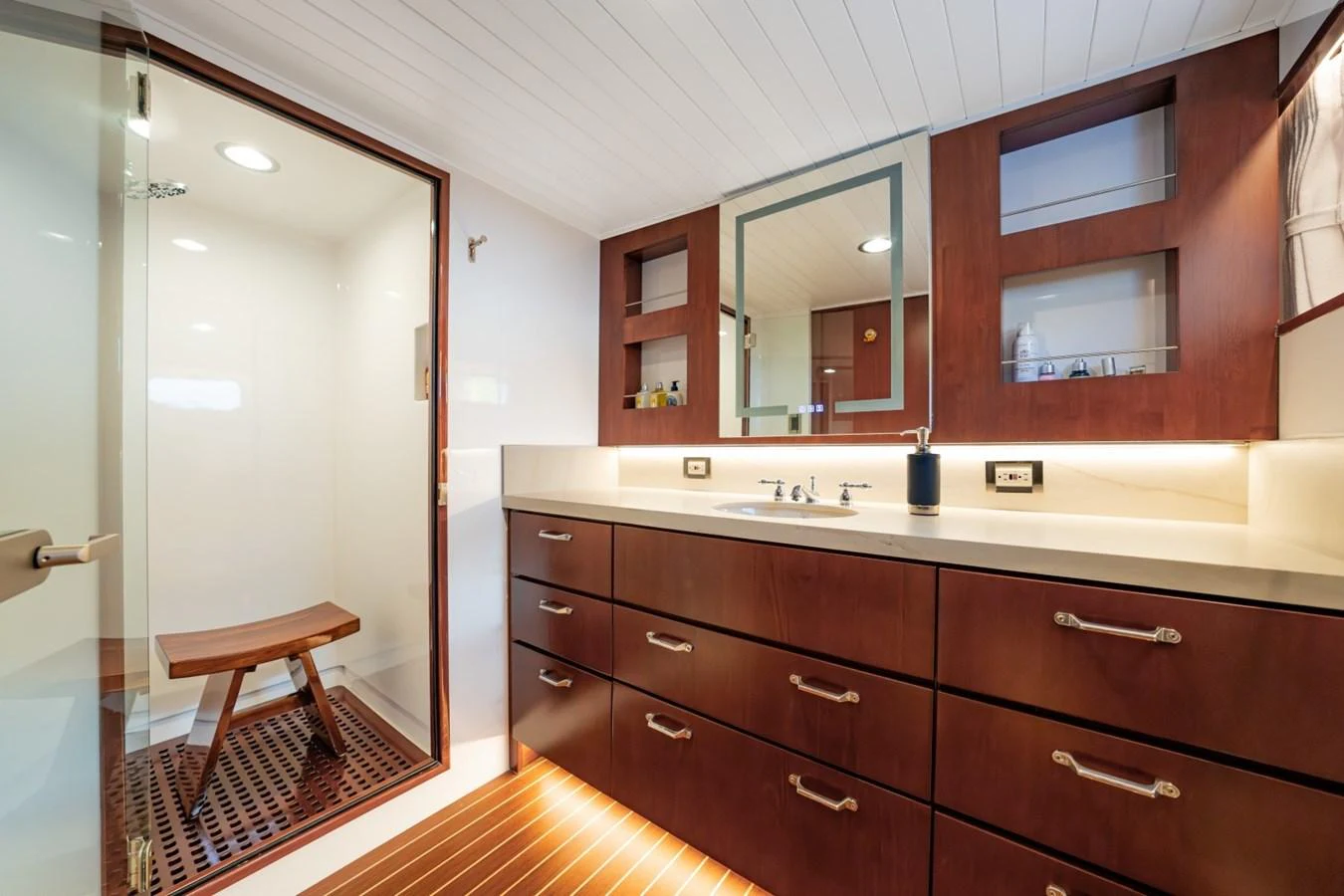 The yacht's bathroom features elegant wooden cabinetry and a spacious shower area. aboard PASSAGE Yacht for Sale