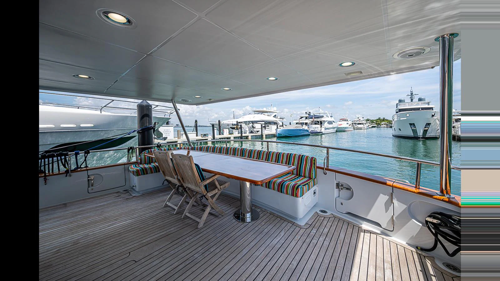 The aft deck offers a spacious and comfortable area for outdoor dining and relaxation with a view of the marina. aboard TURANGALILA Yacht for Sale