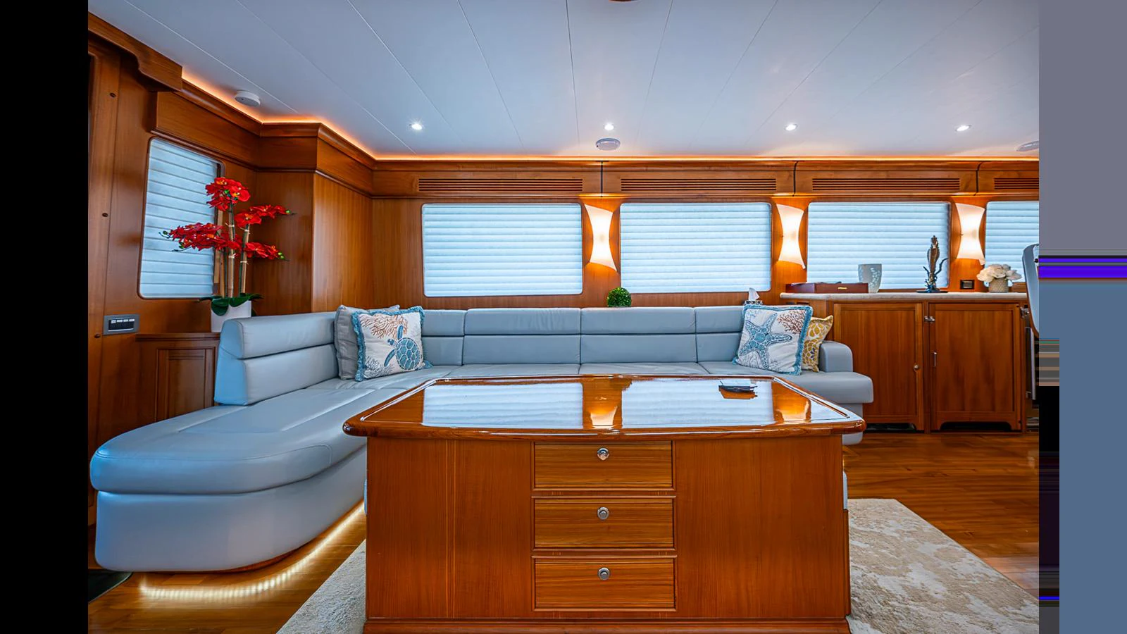 The salon features elegant wood paneling, plush seating, and ample natural light. aboard TURANGALILA Yacht for Sale