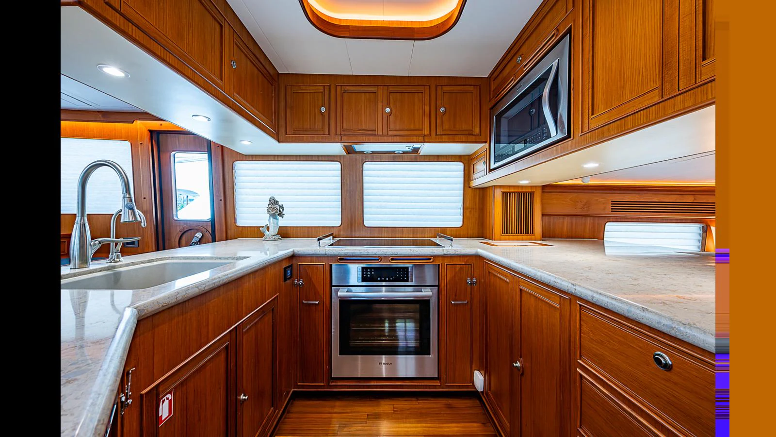 The yacht's galley features rich wooden cabinetry, modern appliances, and ample counter space. aboard TURANGALILA Yacht for Sale