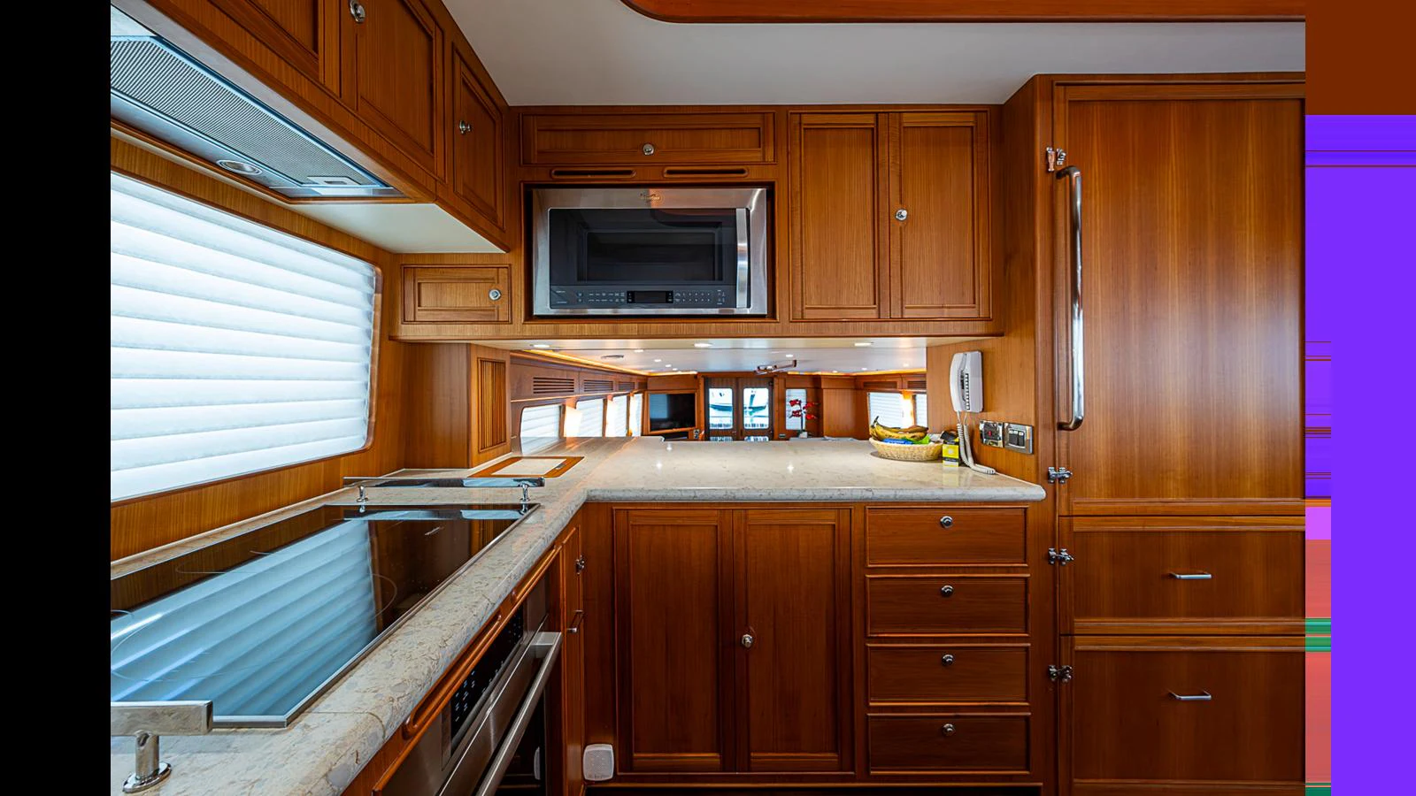 The galley features rich wooden cabinetry and modern appliances, creating a warm and functional space. aboard TURANGALILA Yacht for Sale