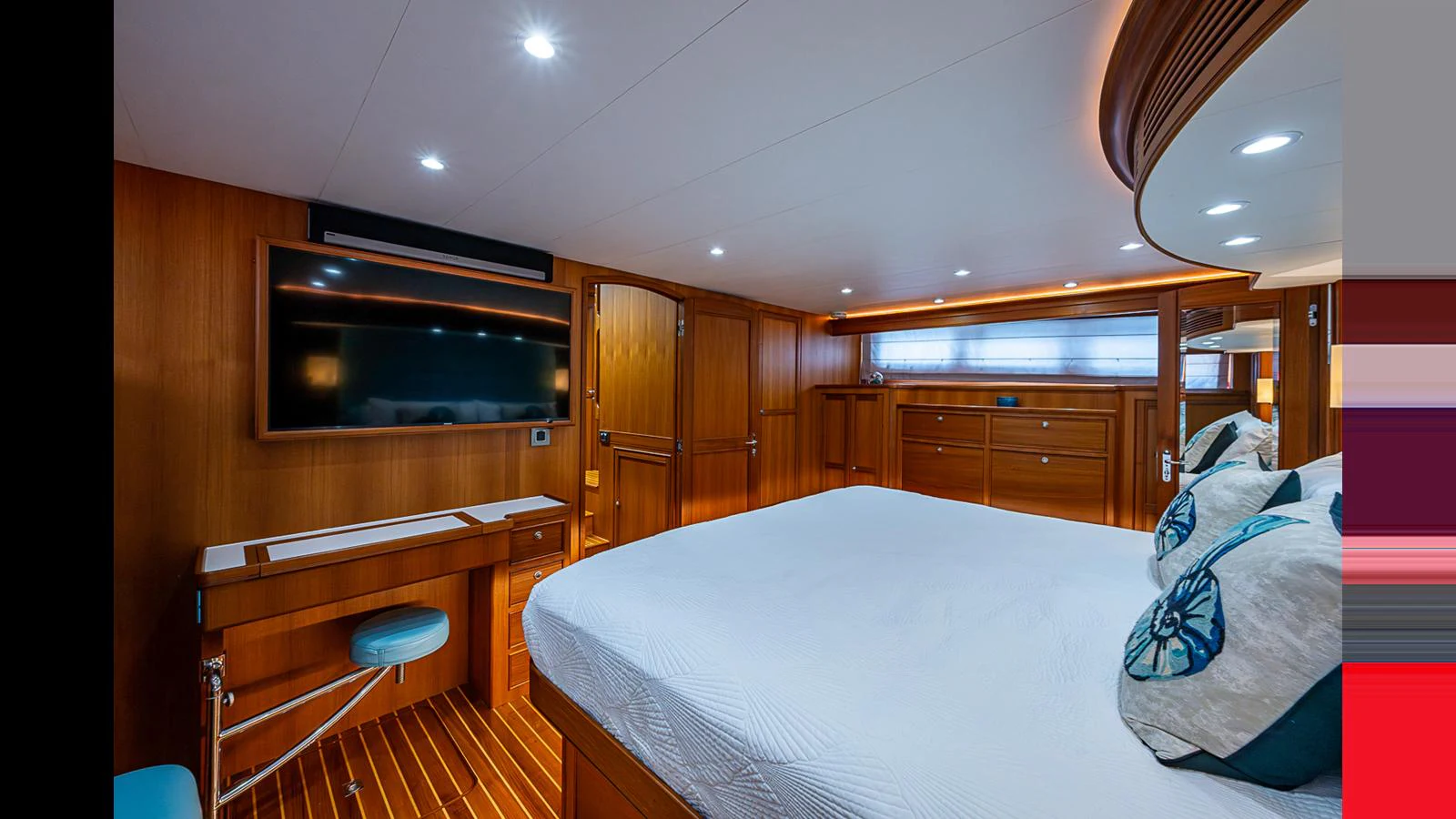 The master stateroom features a spacious bed, wooden cabinetry, and a flat-screen TV for ultimate comfort. aboard TURANGALILA Yacht for Sale