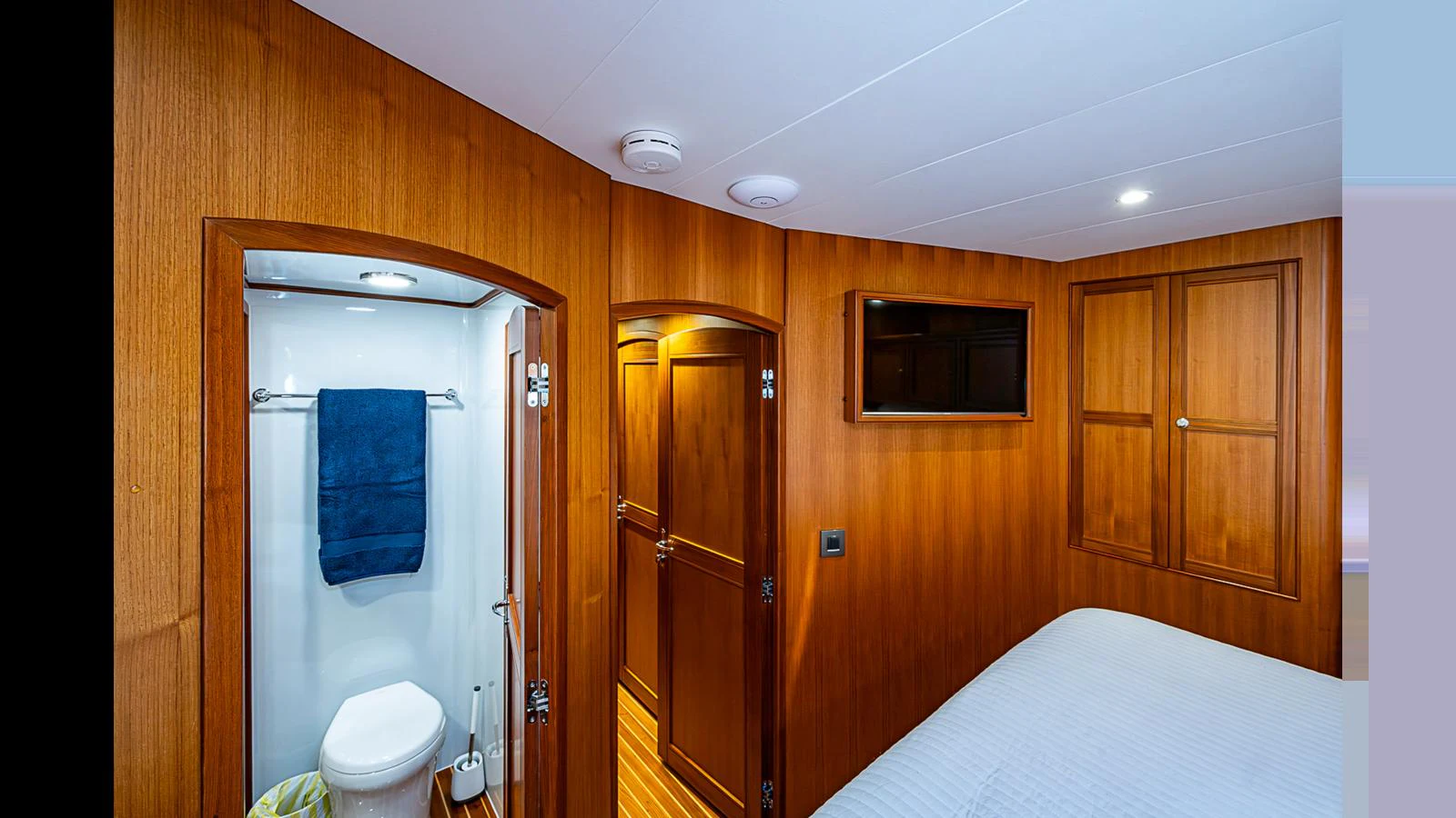The guest cabin features warm wood paneling and a private en-suite bathroom. aboard TURANGALILA Yacht for Sale