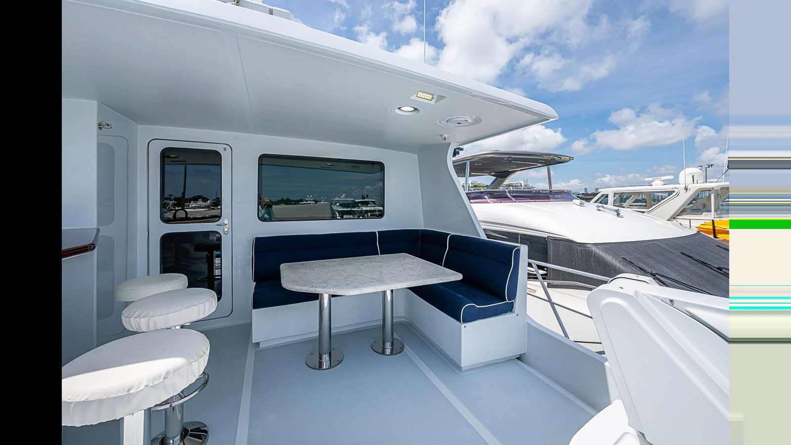 The aft deck features a comfortable seating area with a table, perfect for outdoor dining and relaxation. aboard TURANGALILA Yacht for Sale
