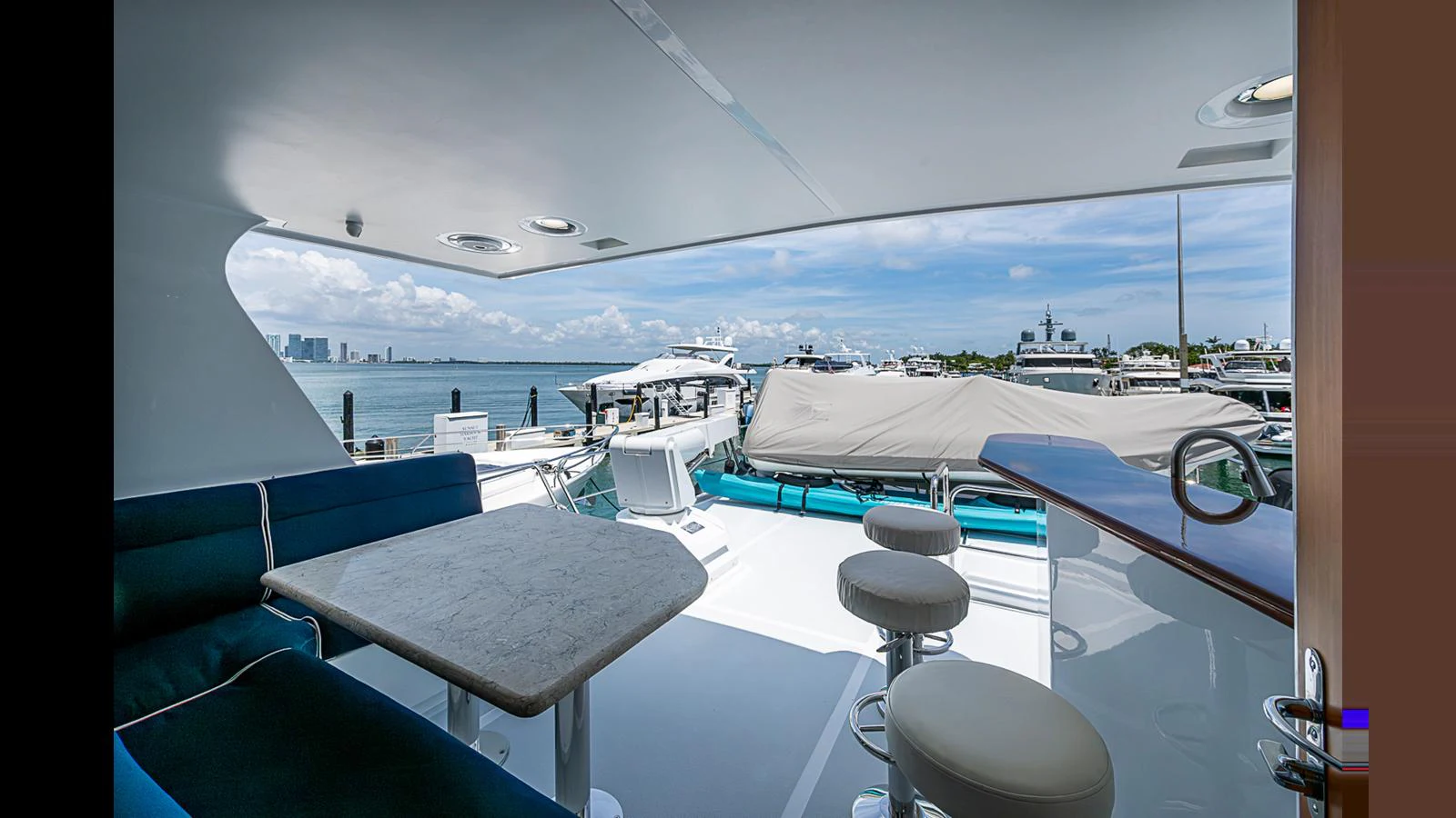 The aft deck offers a spacious and inviting area with a dining table and bar seating, perfect for enjoying the scenic views. aboard TURANGALILA Yacht for Sale