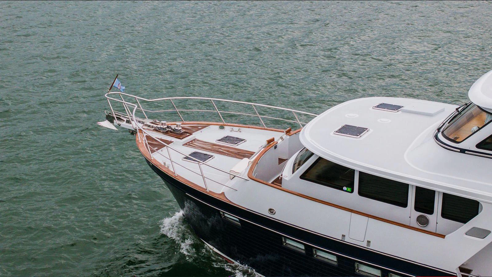 A sleek yacht glides through the water, showcasing its elegant bow and modern design. aboard TURANGALILA Yacht for Sale