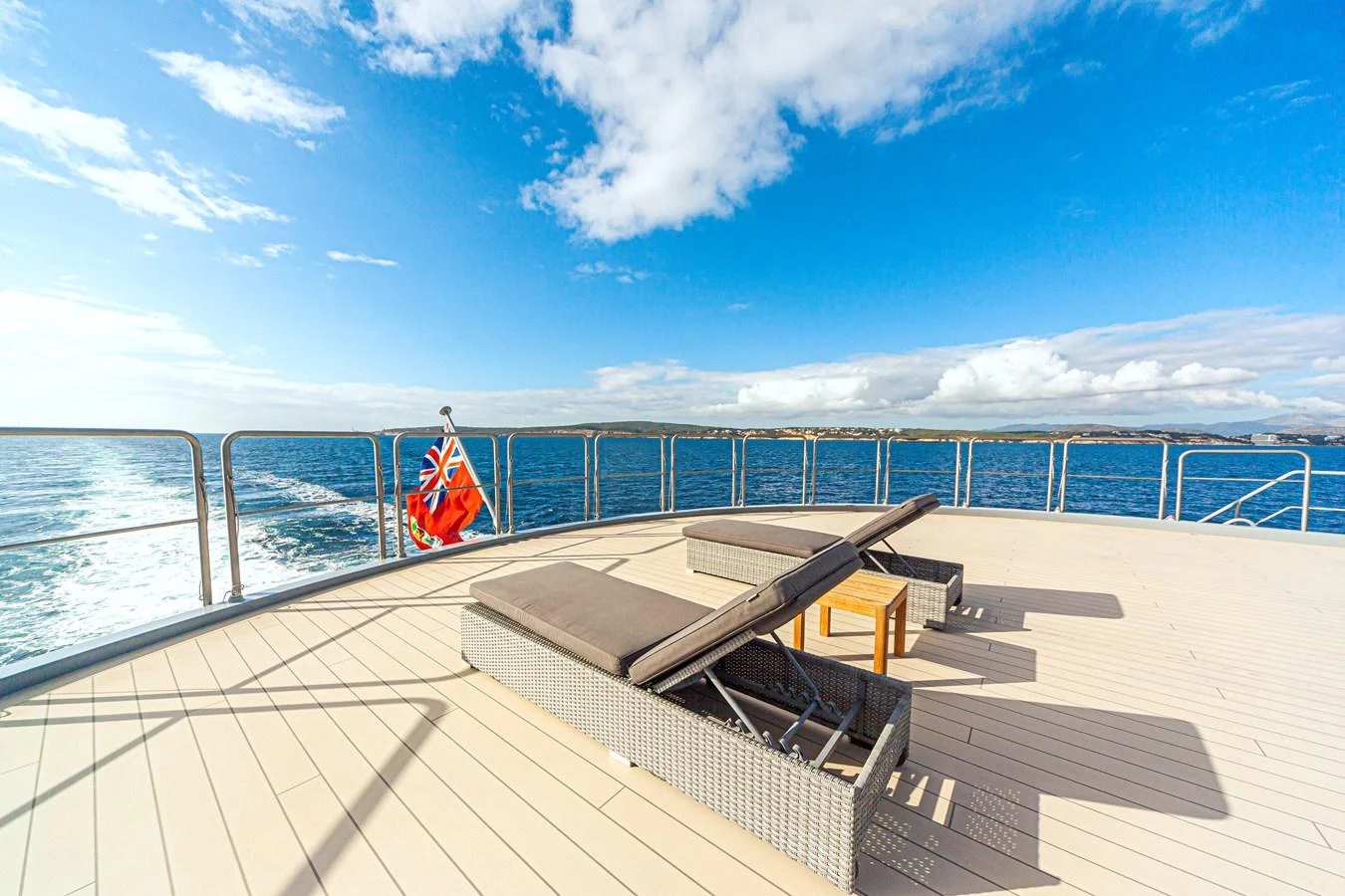 The sundeck offers a serene space with lounge chairs and a stunning ocean view. aboard NURJA Yacht for Sale