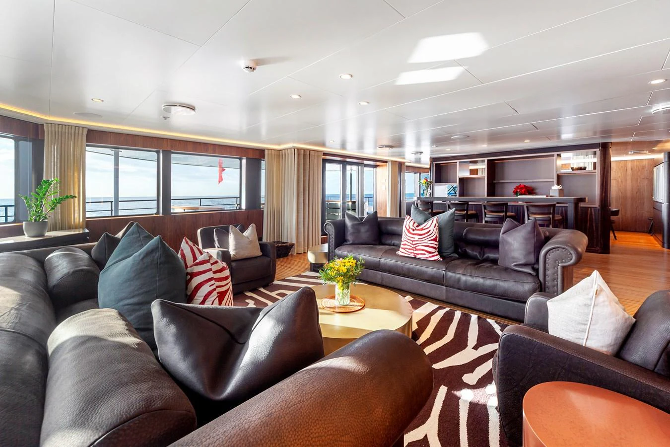 The spacious salon features luxurious leather seating, large windows, and elegant decor. aboard NURJA Yacht for Sale
