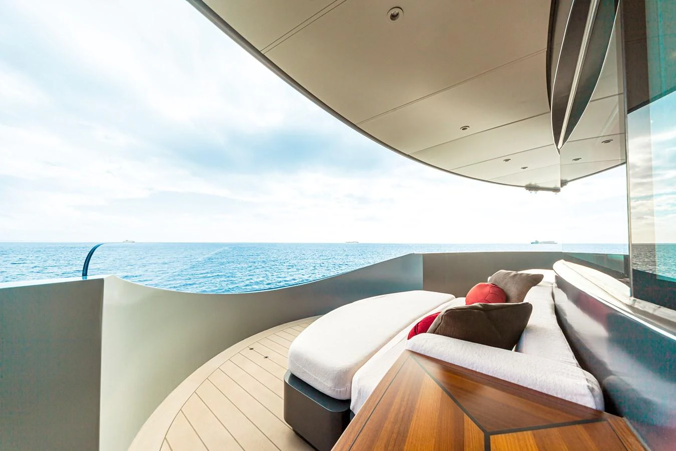 A luxurious balcony area with comfortable seating and stunning ocean views. aboard NURJA Yacht for Sale