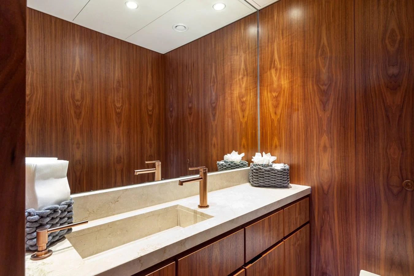 A luxurious yacht bathroom featuring elegant wood paneling and modern fixtures. aboard NURJA Yacht for Sale