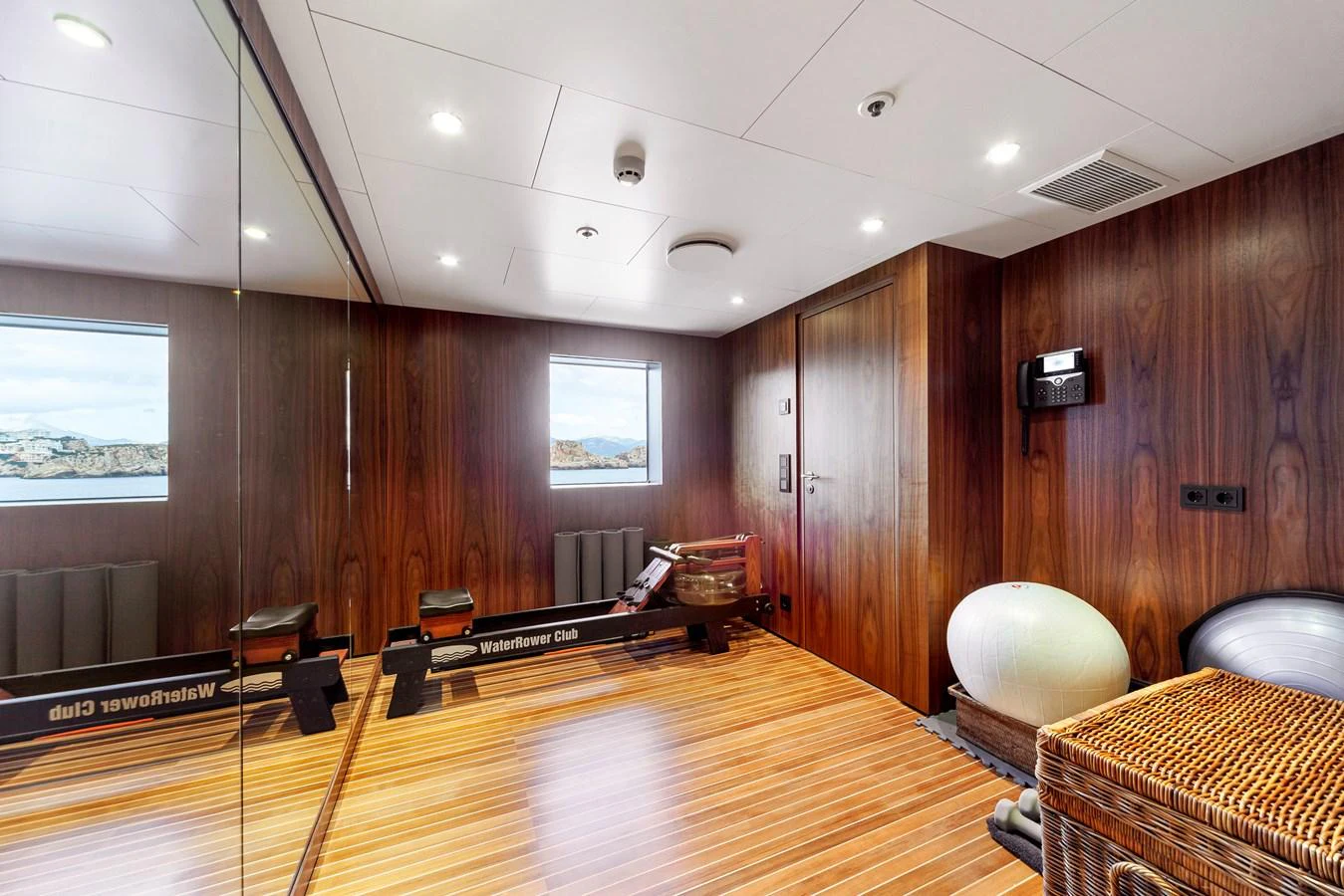 The yacht's gym features modern equipment and a serene ambiance with wood paneling and natural light. aboard NURJA Yacht for Sale