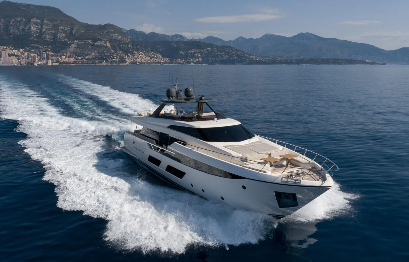 A sleek yacht cruises through calm waters with a stunning coastal backdrop. aboard ALEGRIA II Yacht for Sale