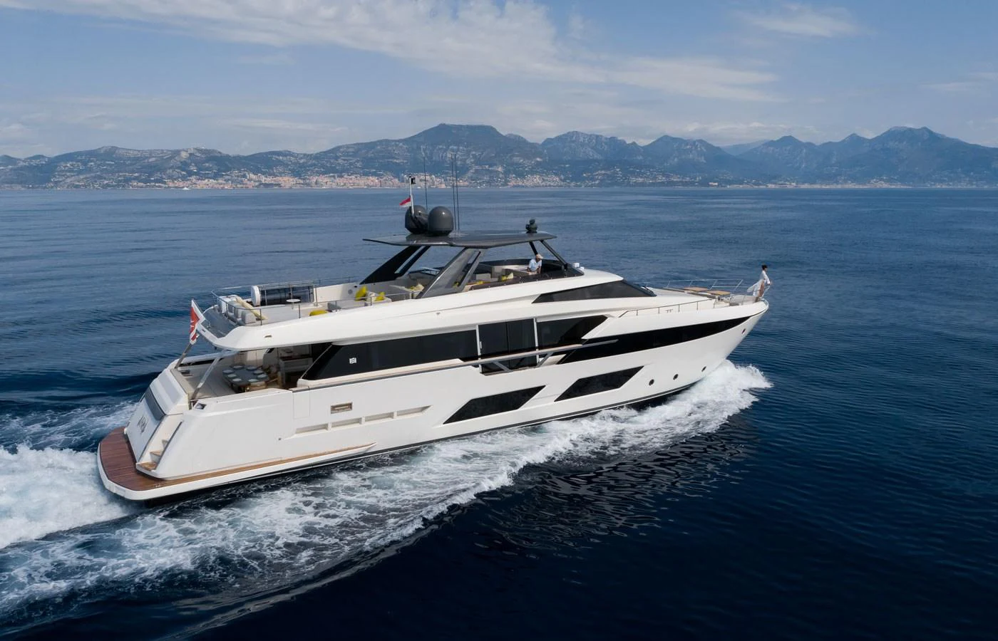 A sleek and modern yacht cruising on calm waters with a scenic mountainous backdrop. aboard ALEGRIA II Yacht for Sale