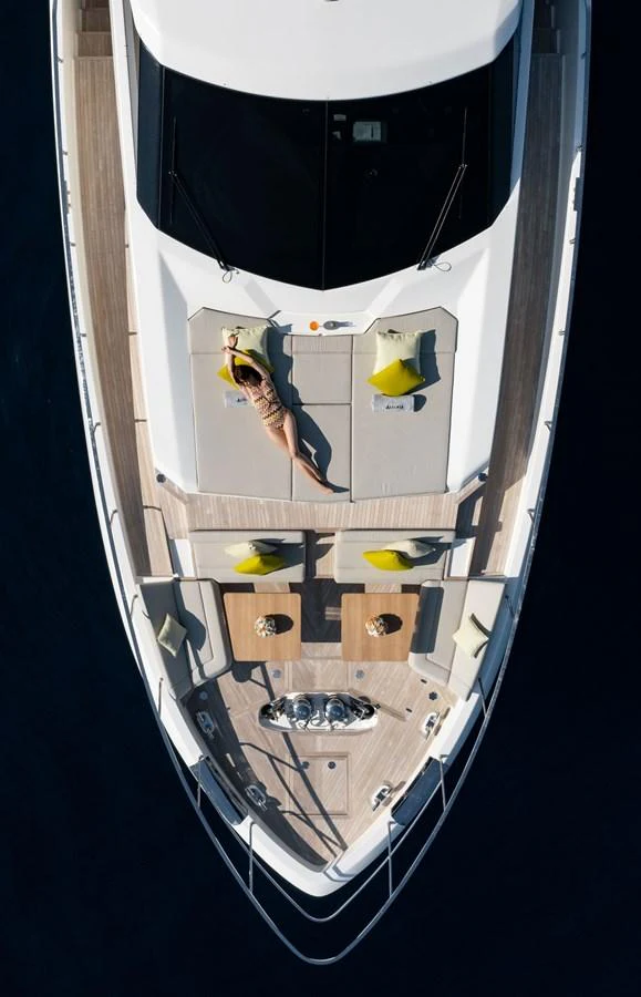The foredeck features a luxurious sunbathing area with comfortable cushions and a stylish table setup. aboard ALEGRIA II Yacht for Sale