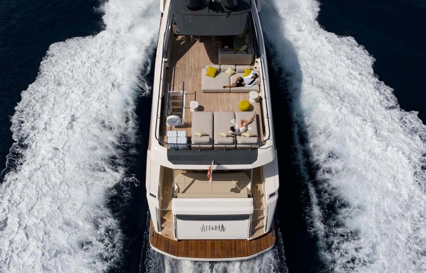 A luxurious yacht cruising through the water, showcasing its spacious and stylish aft deck. aboard ALEGRIA II Yacht for Sale