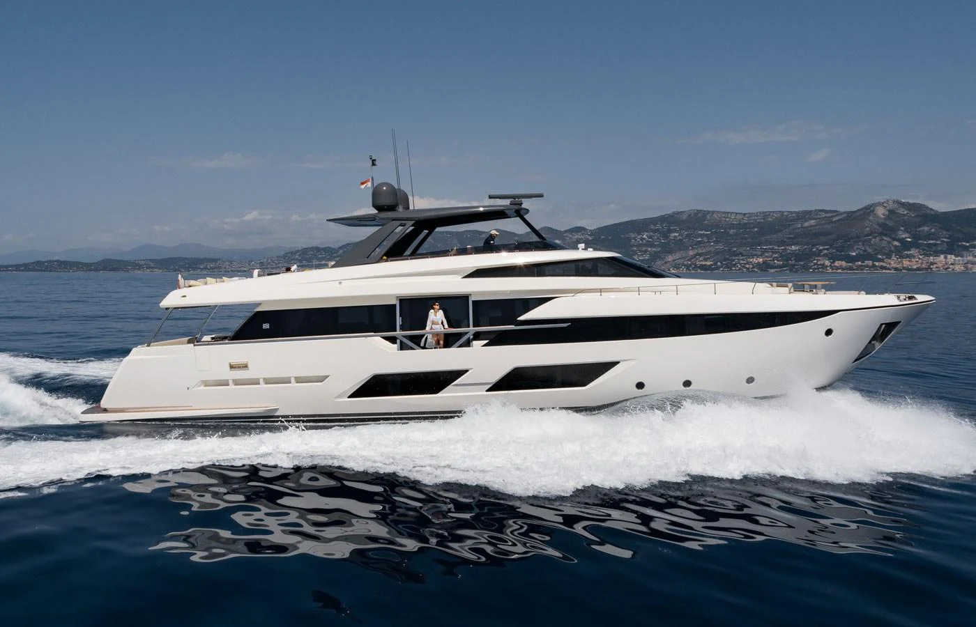 A sleek and modern yacht cruising on calm waters with a scenic coastal backdrop. aboard ALEGRIA II Yacht for Sale