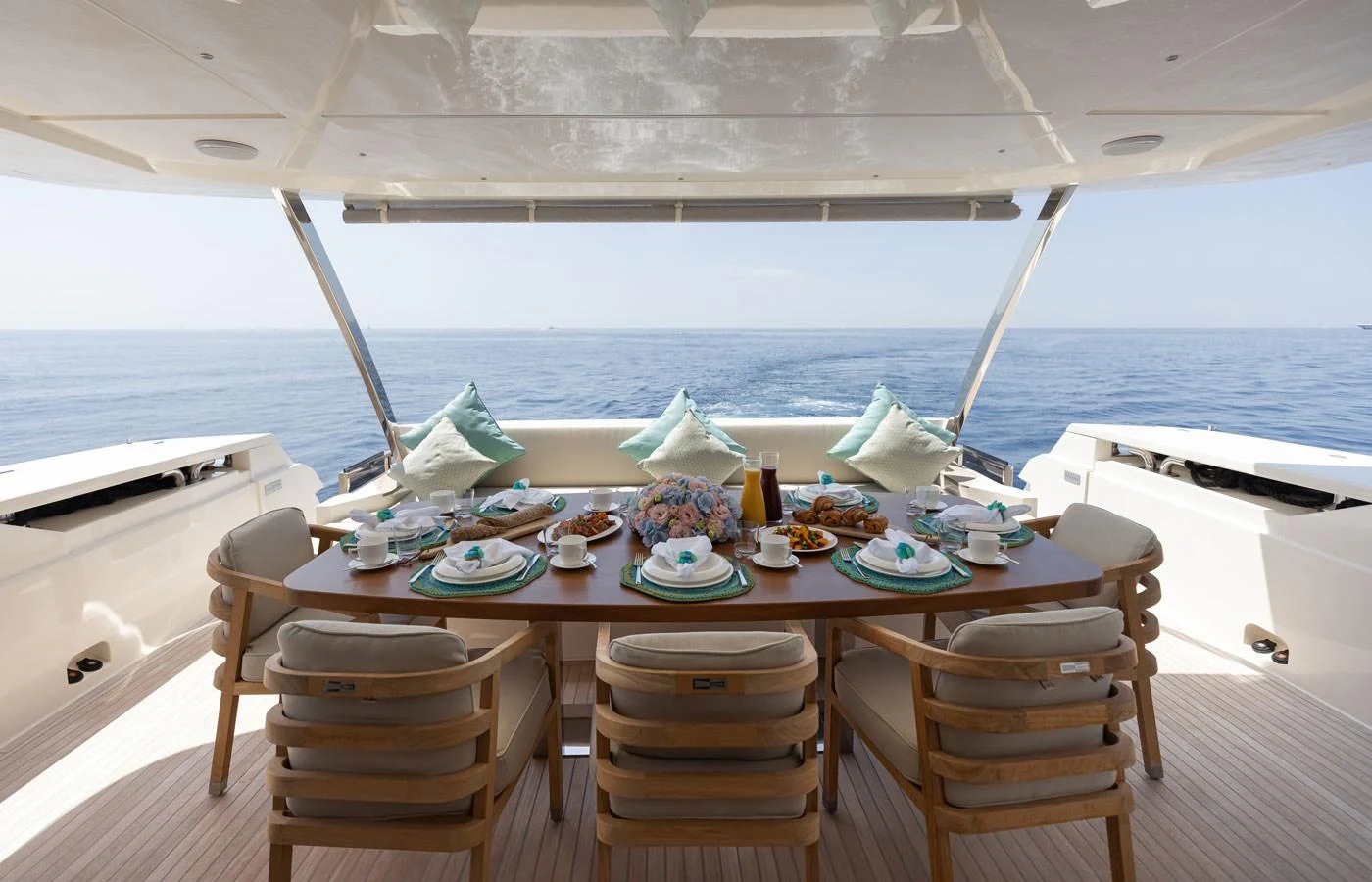 The aft deck features a beautifully set dining table with a stunning ocean view. aboard ALEGRIA II Yacht for Sale