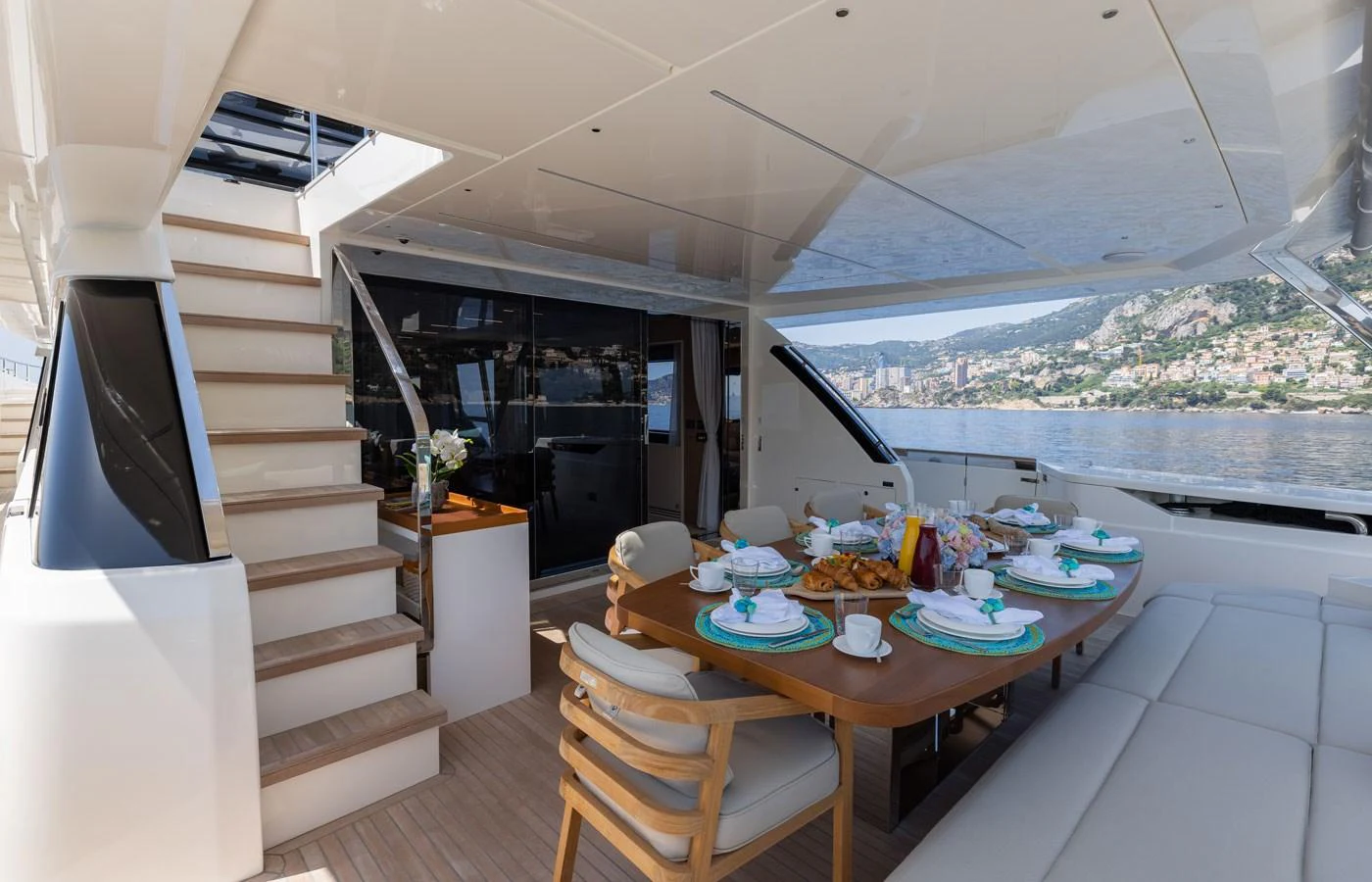 The aft deck features a stylish dining area with a scenic view. aboard ALEGRIA II Yacht for Sale