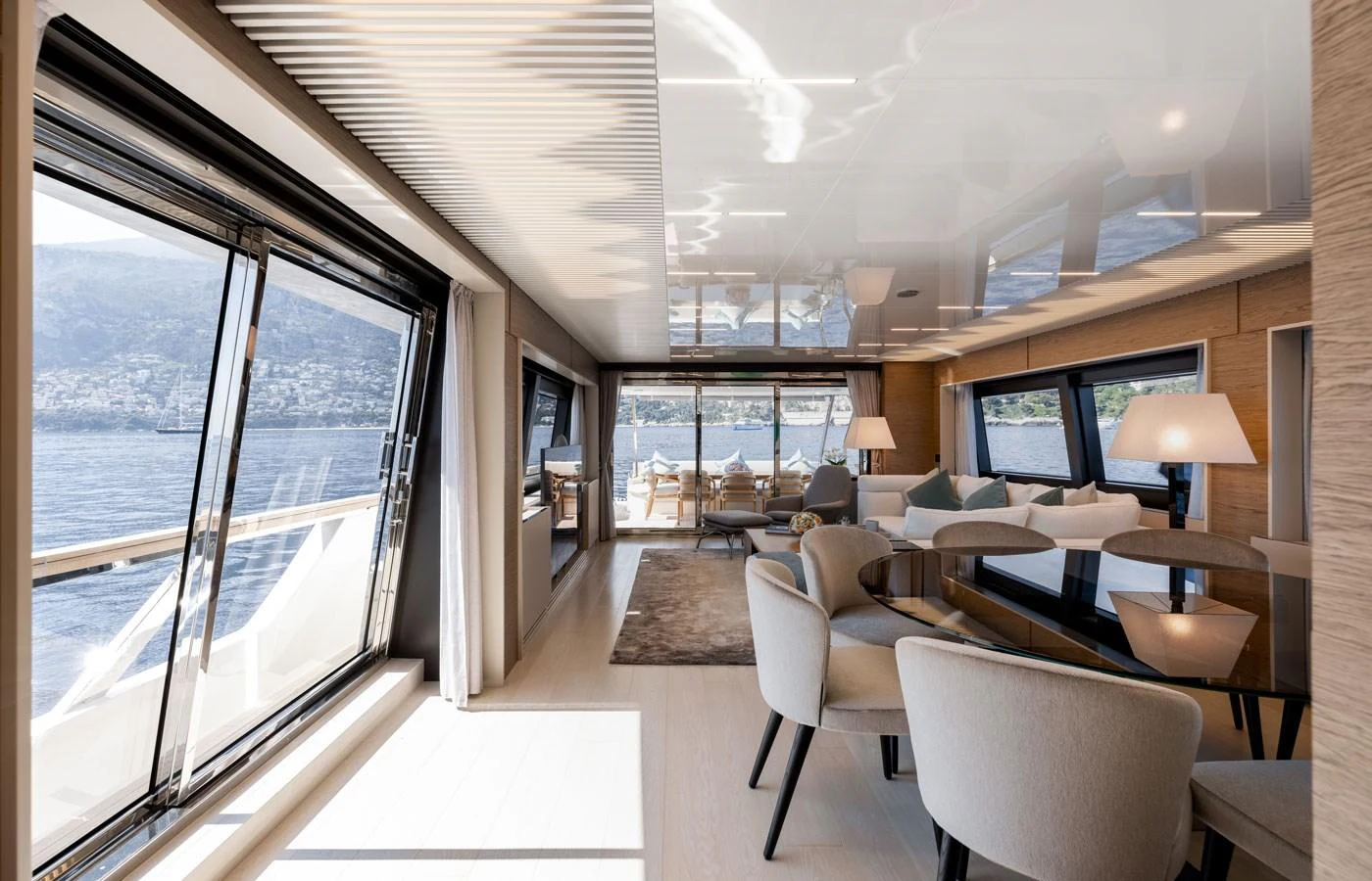 The salon features expansive windows and elegant furnishings with a view of the water. aboard ALEGRIA II Yacht for Sale