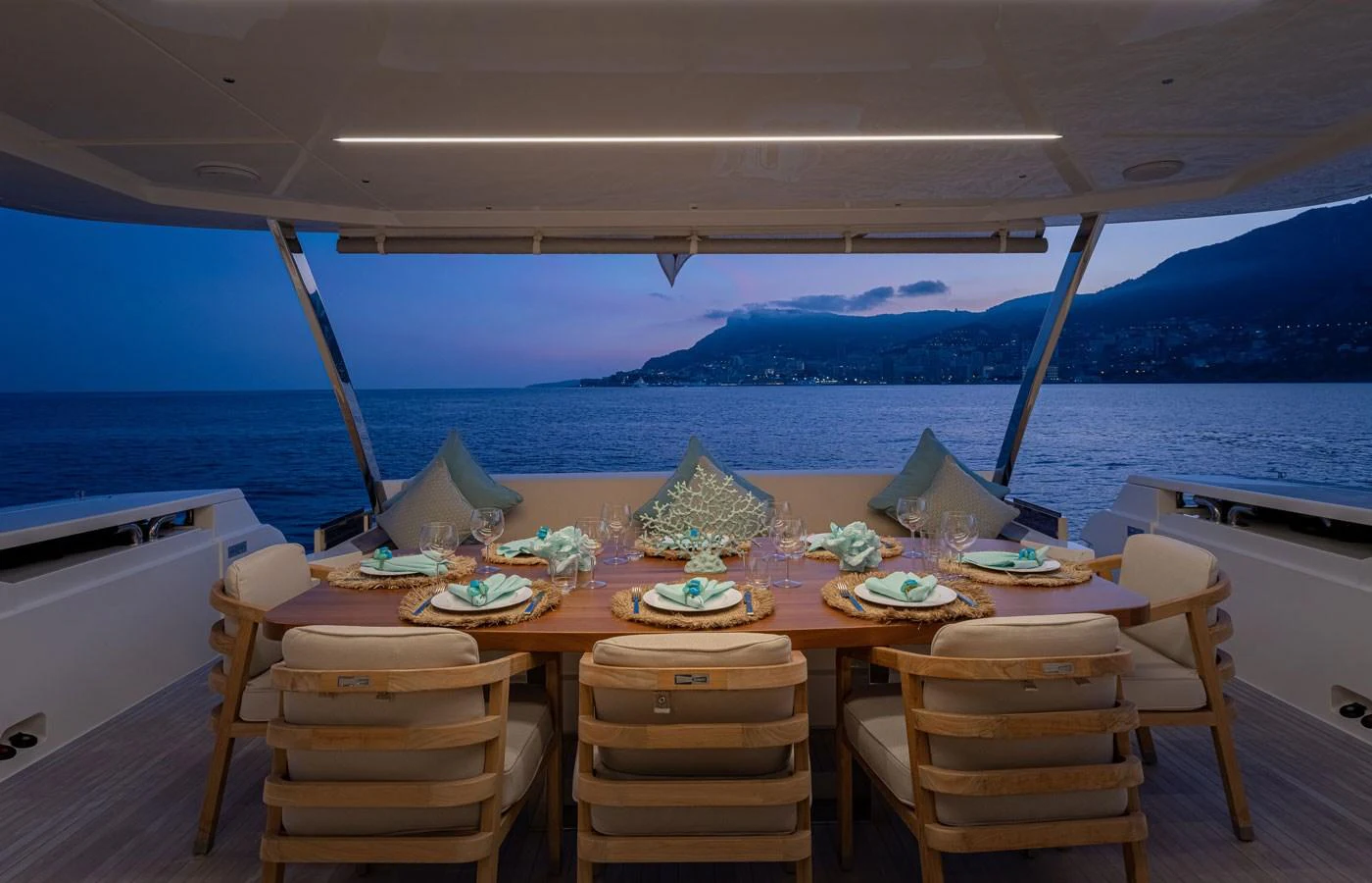 The aft deck features an elegant dining area with a stunning view of the sea at dusk. aboard ALEGRIA II Yacht for Sale