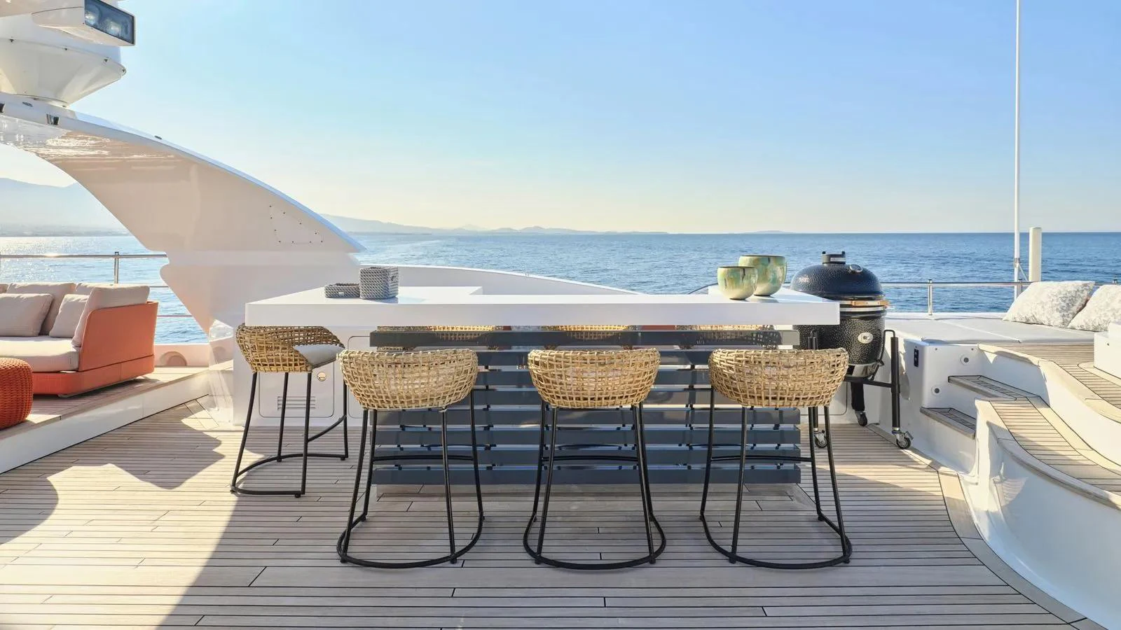 The aft deck features a stylish bar area with wicker stools, perfect for outdoor dining and relaxation. aboard THEOLINA Yacht for Sale