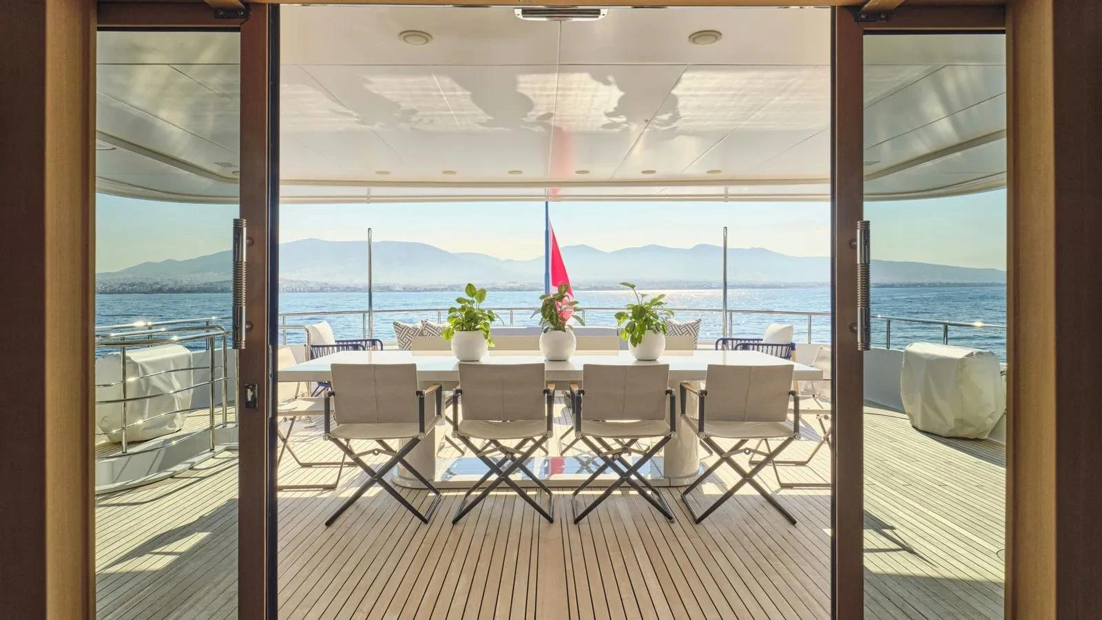 The aft deck features a spacious dining area with a stunning view of the sea. aboard THEOLINA Yacht for Sale