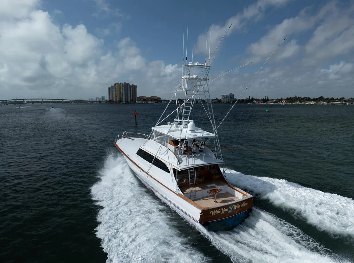 A sleek yacht cruises swiftly through the water, showcasing its powerful design and elegant lines. aboard WISH YOU WERE HERE Yacht for Sale