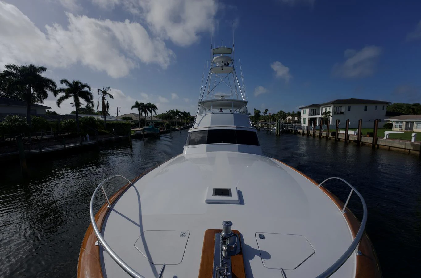 The yacht is docked in a serene marina under a partly cloudy sky. aboard WISH YOU WERE HERE Yacht for Sale