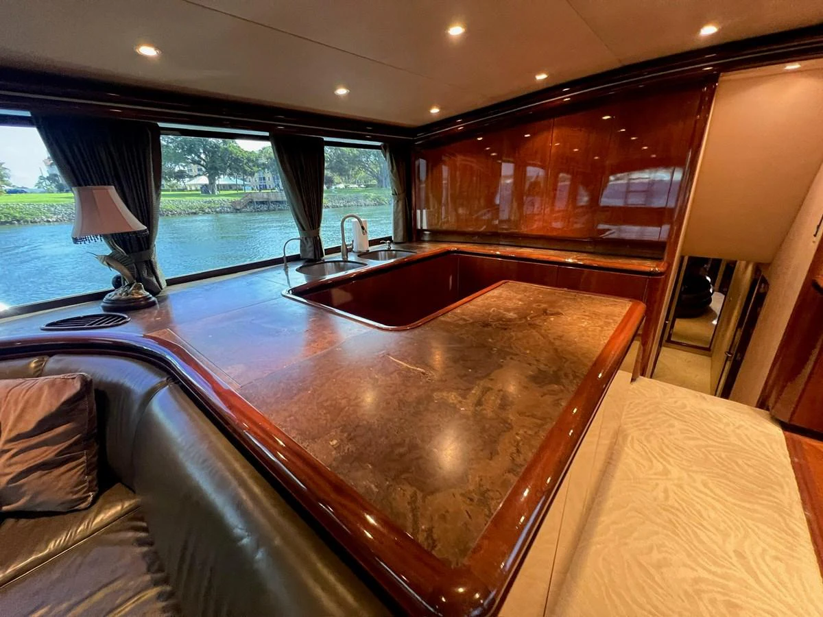 The yacht's galley features a luxurious countertop with ample space and a large window offering scenic views. aboard WISH YOU WERE HERE Yacht for Sale