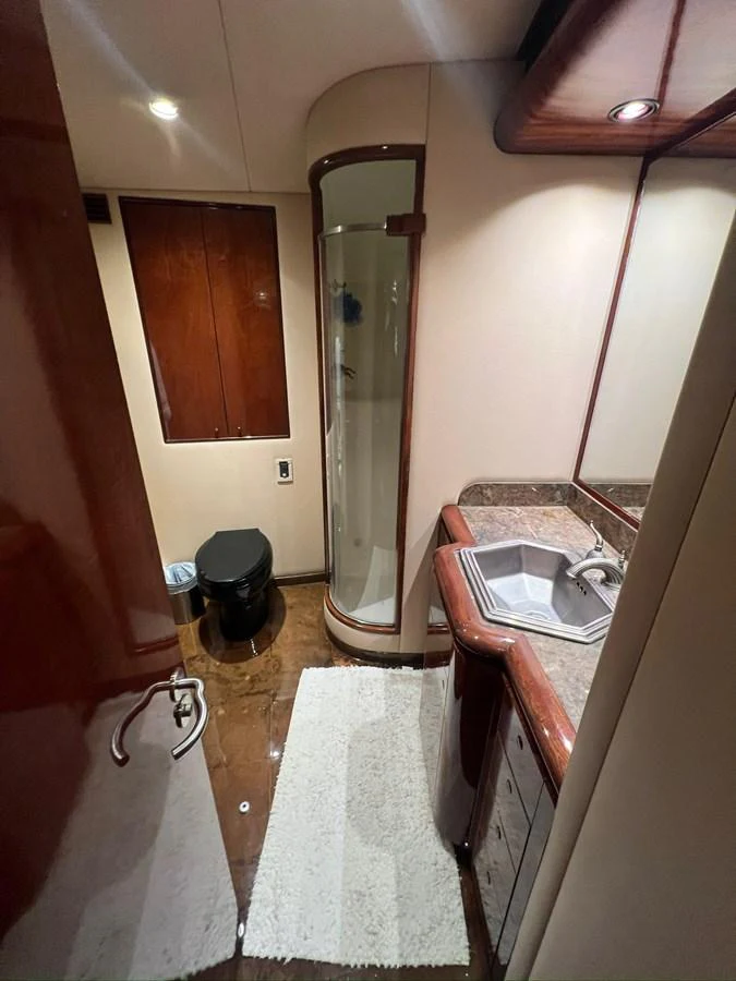 The yacht's bathroom features a sleek design with a shower, sink, and toilet. aboard WISH YOU WERE HERE Yacht for Sale