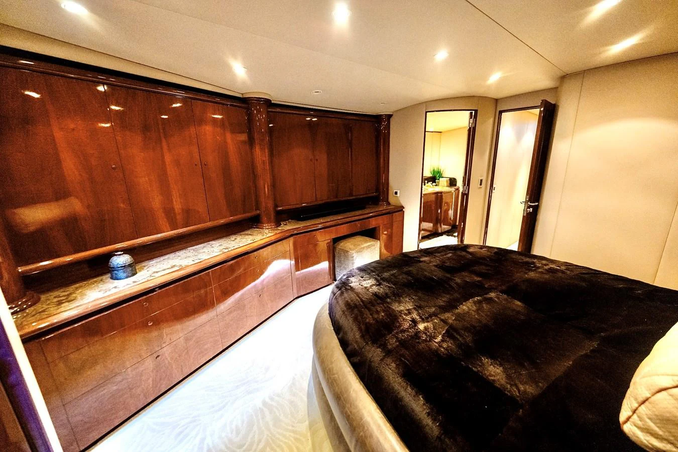A luxurious stateroom featuring rich wood cabinetry and a plush bed. aboard WISH YOU WERE HERE Yacht for Sale