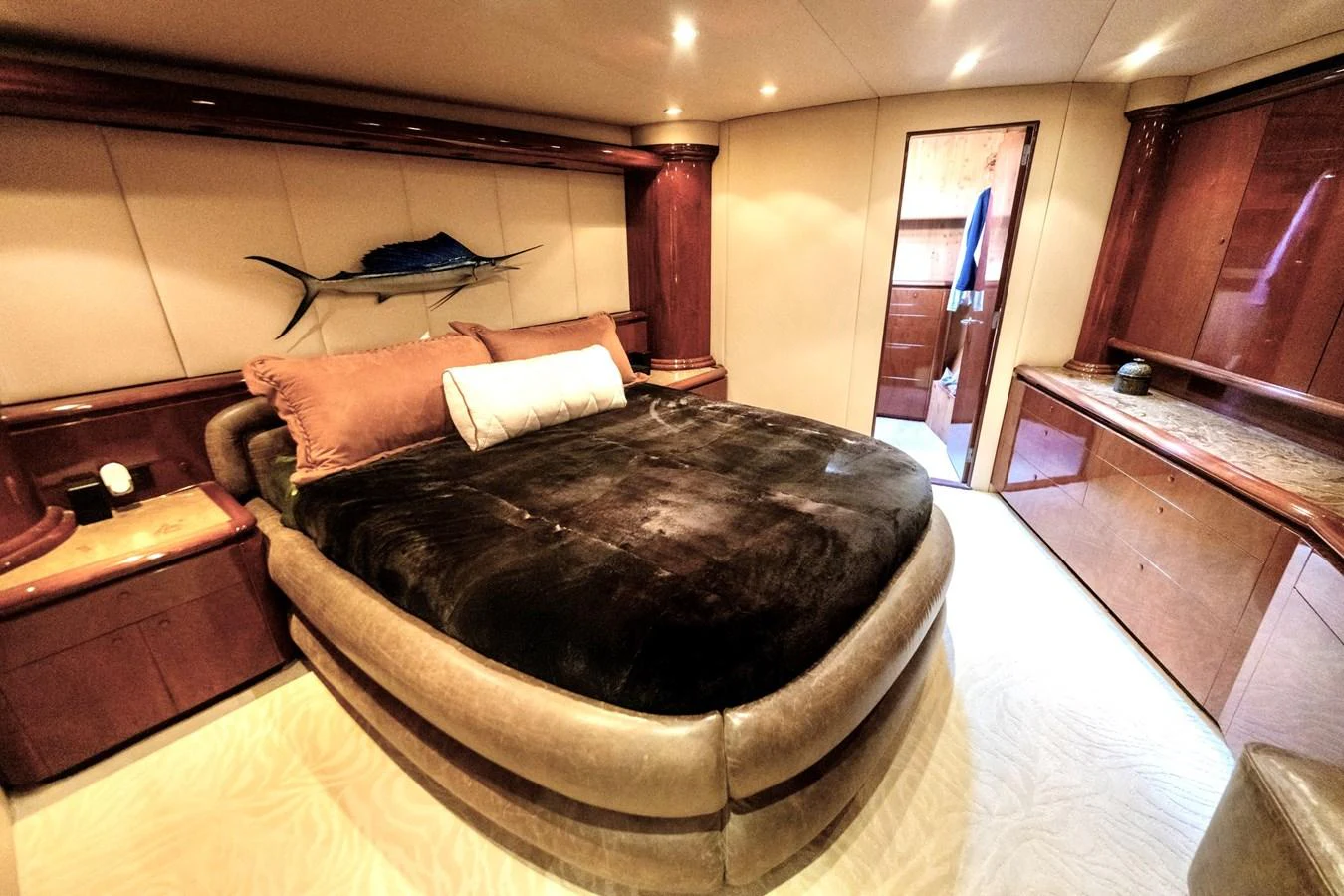 The master stateroom features a luxurious bed with plush bedding and elegant wood finishes. aboard WISH YOU WERE HERE Yacht for Sale