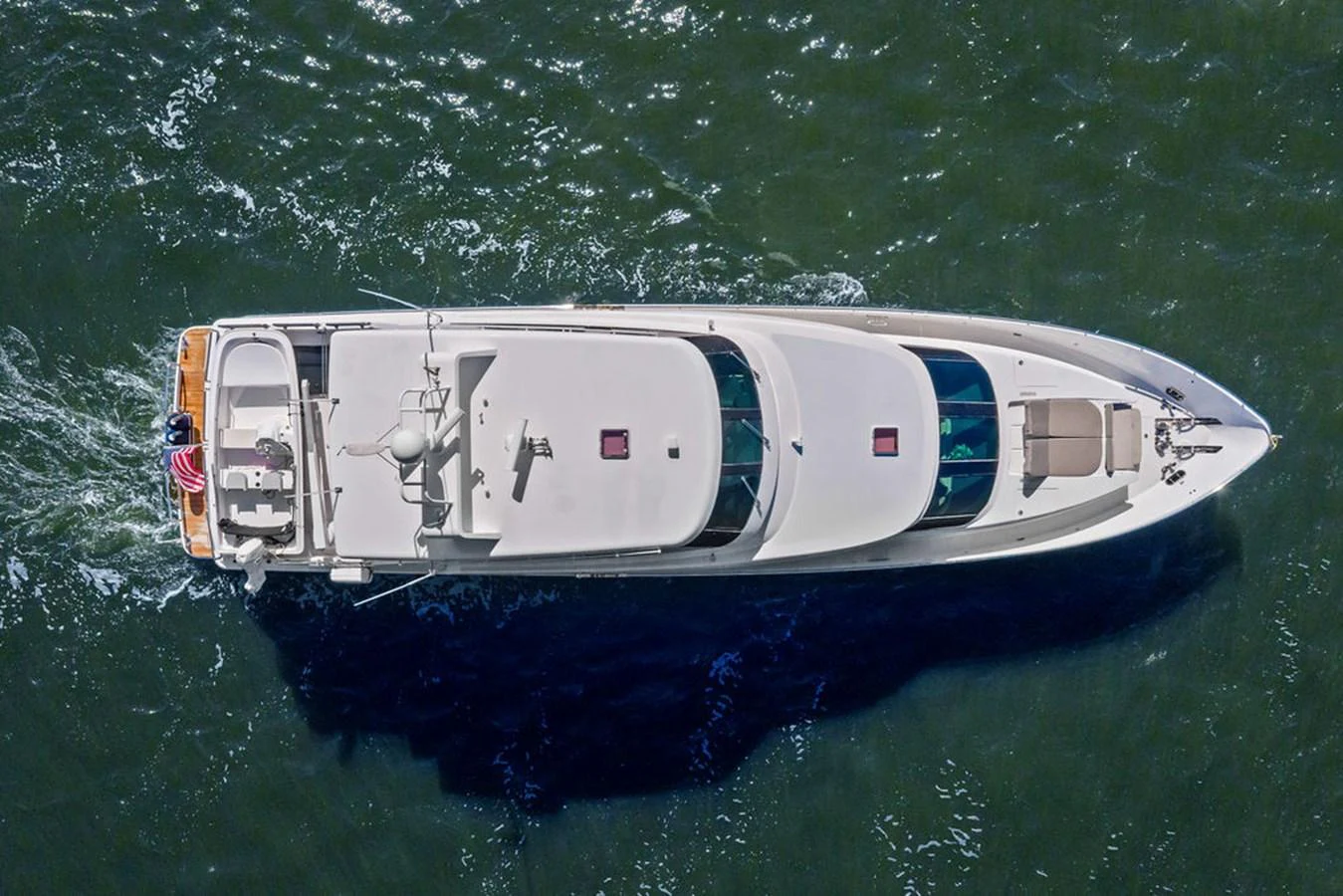 A sleek yacht glides through the water, showcasing its elegant design from an aerial perspective. aboard BABE Yacht for Sale