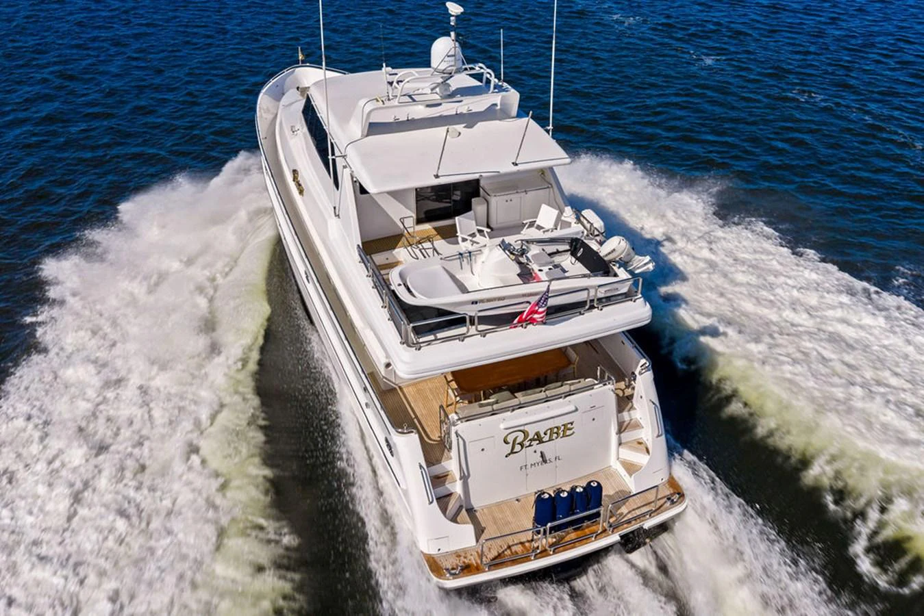 A luxurious yacht cruises through the water, showcasing its spacious aft deck and sleek design. aboard BABE Yacht for Sale