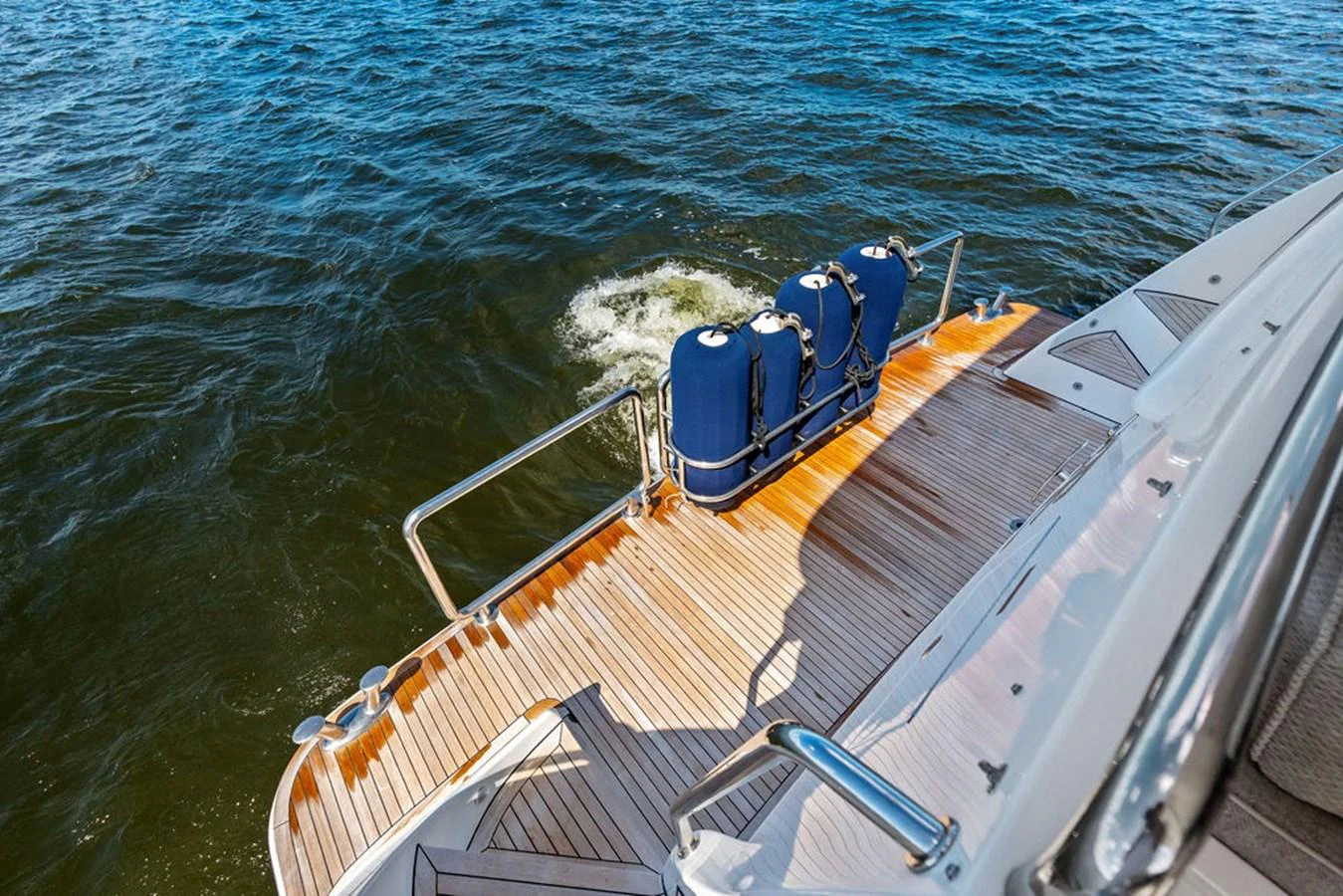 The yacht's swim platform features a teak deck and storage for water toys, providing easy access to the water. aboard BABE Yacht for Sale