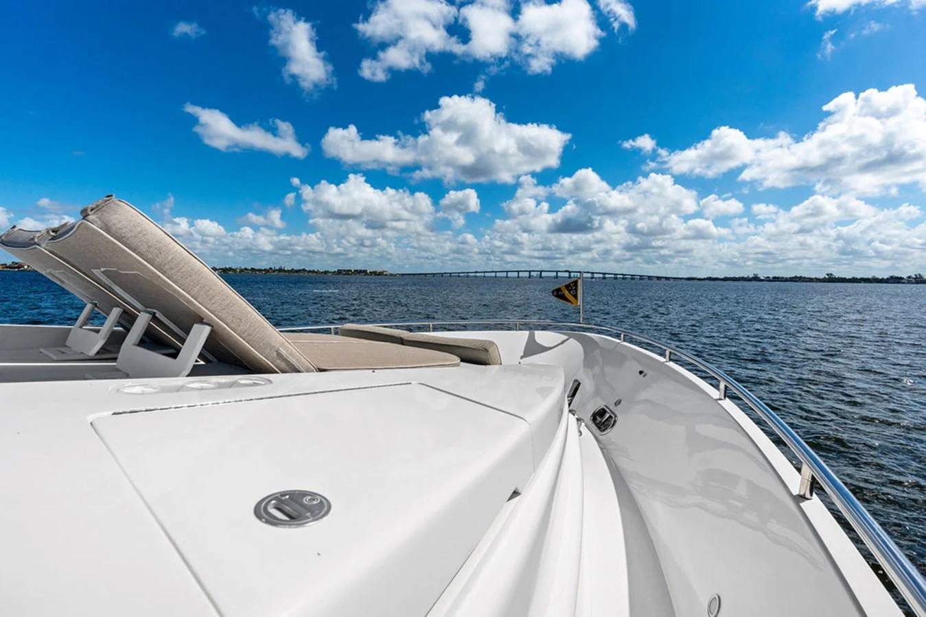 A luxurious yacht deck with sun loungers, set against a serene ocean backdrop. aboard BABE Yacht for Sale