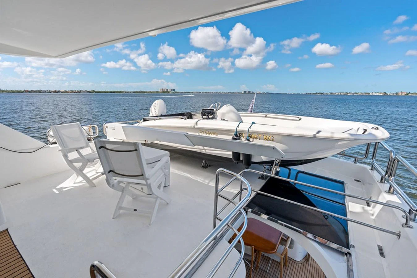 The aft deck features a tender boat and seating area with stunning water views. aboard BABE Yacht for Sale