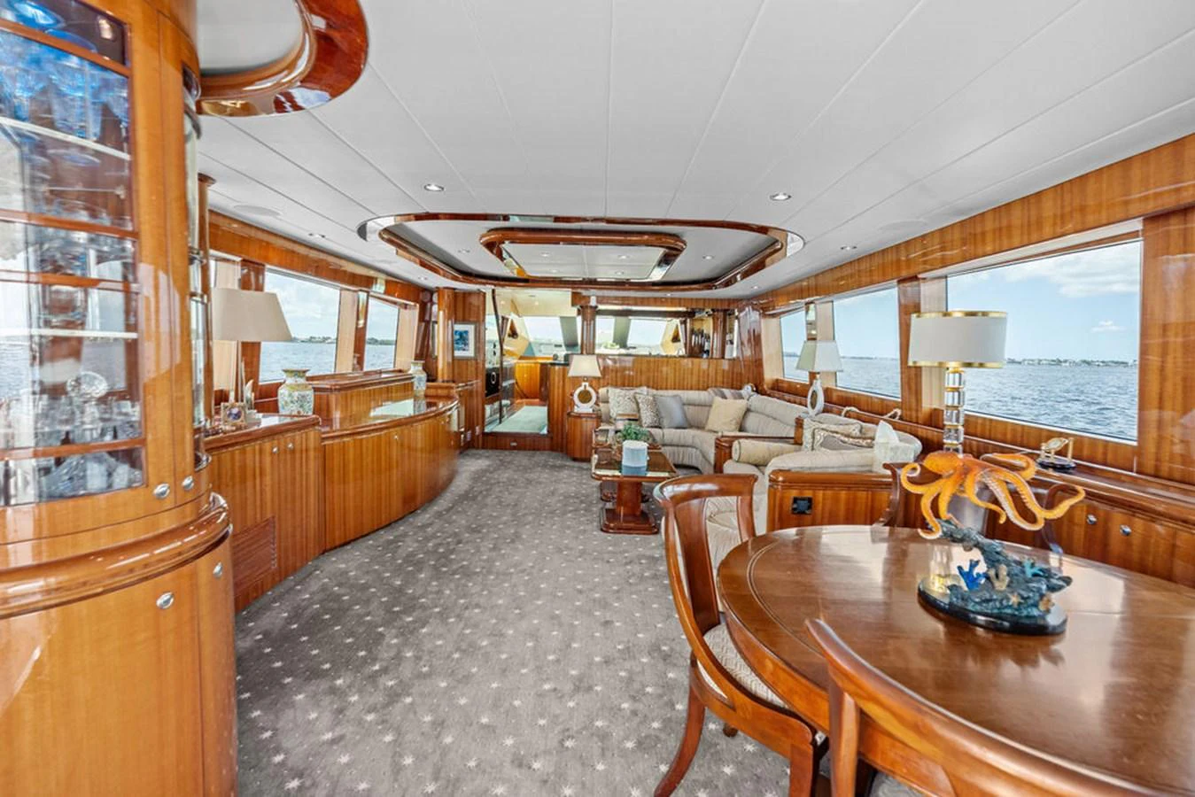 The yacht's salon features elegant wood finishes, plush seating, and large windows offering panoramic views. aboard BABE Yacht for Sale