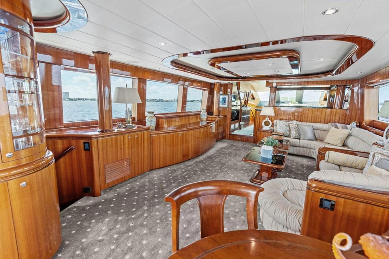 The salon features elegant wood paneling, plush seating, and large windows offering panoramic views. aboard BABE Yacht for Sale