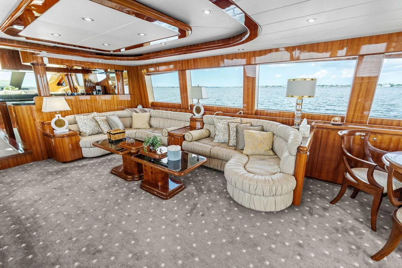 The salon features plush seating, elegant wood finishes, and large windows offering stunning views. aboard BABE Yacht for Sale