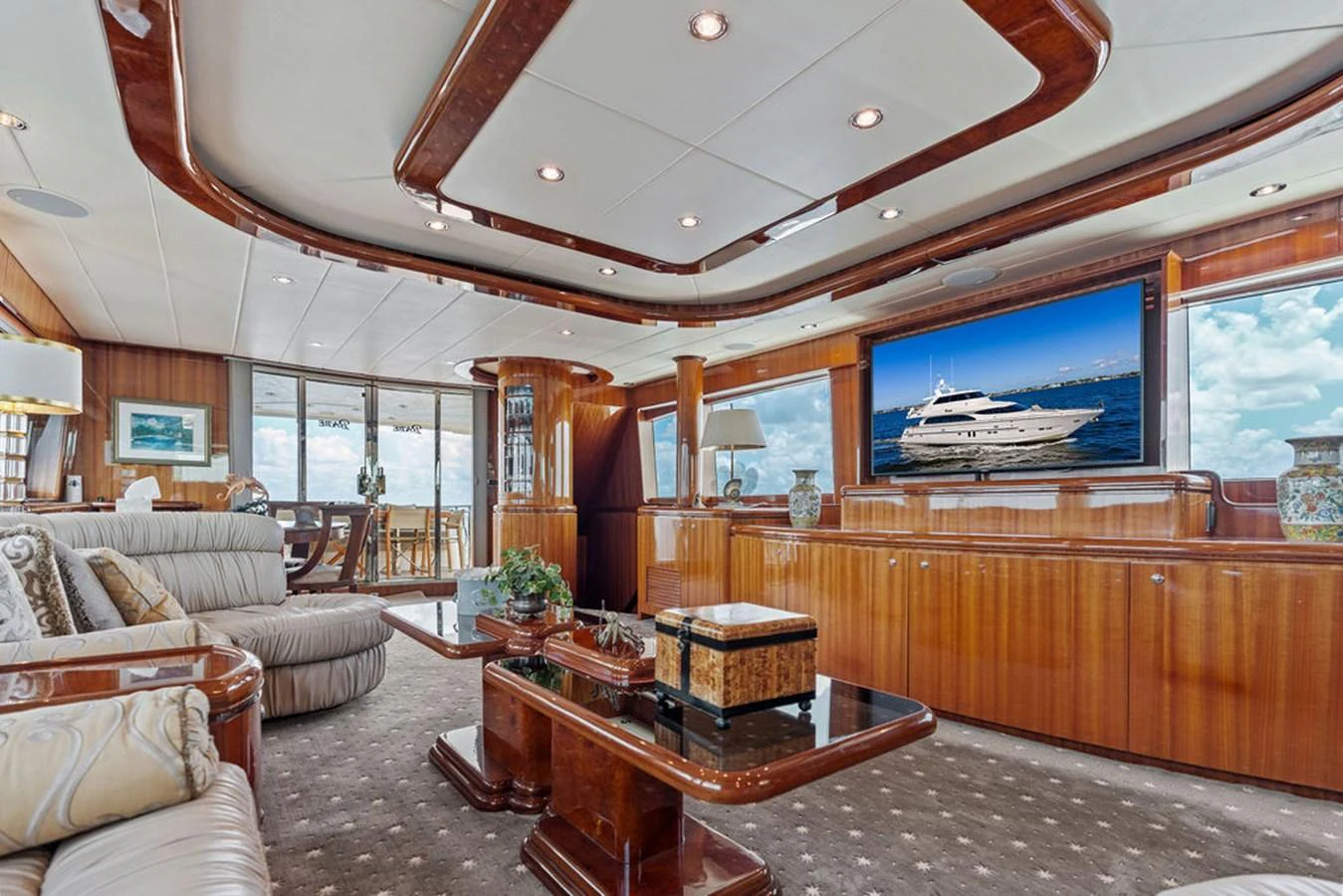 The salon features luxurious seating, a large flat-screen TV, and elegant wooden finishes. aboard BABE Yacht for Sale