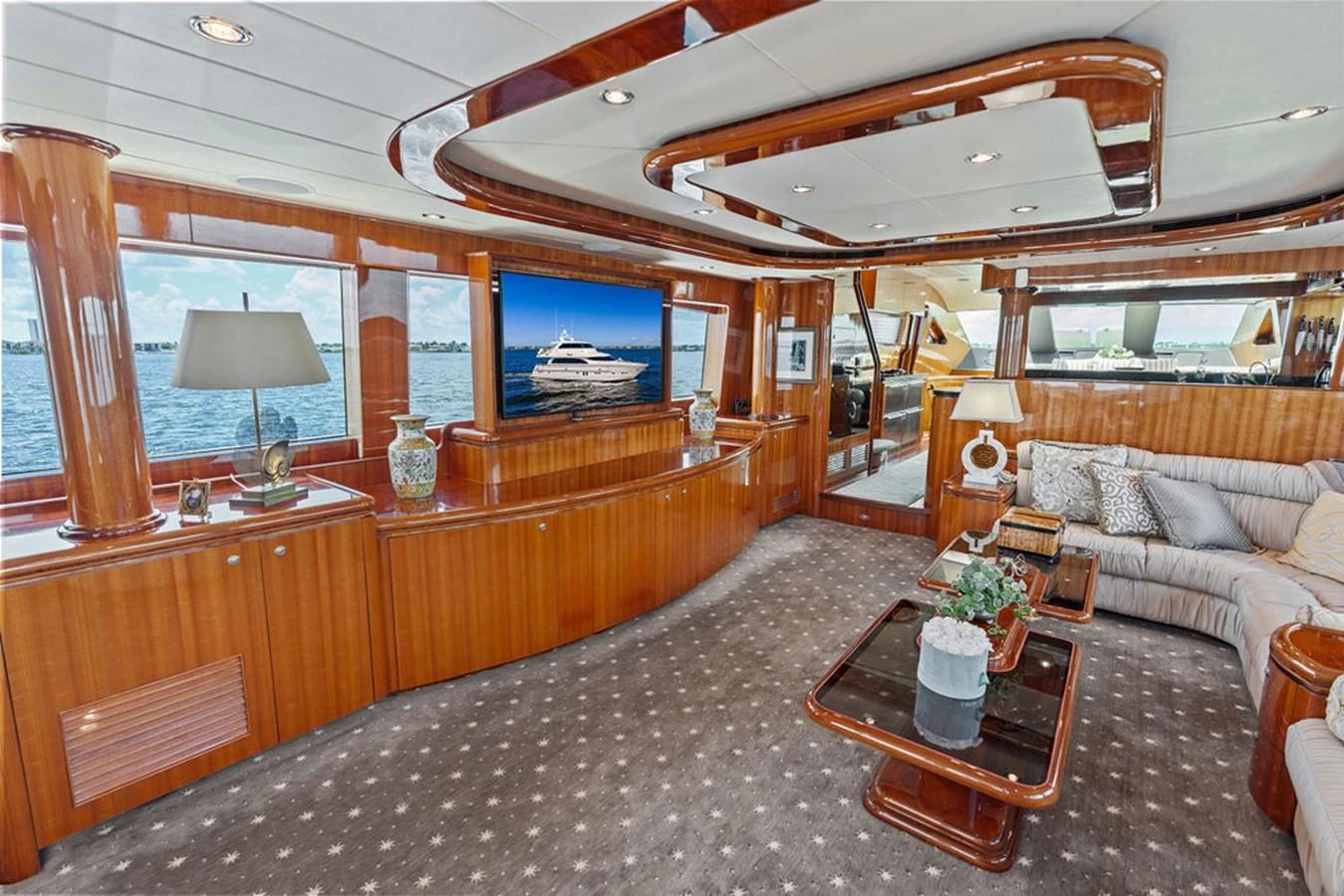 The salon features luxurious wood finishes, plush seating, and large windows offering stunning views. aboard BABE Yacht for Sale