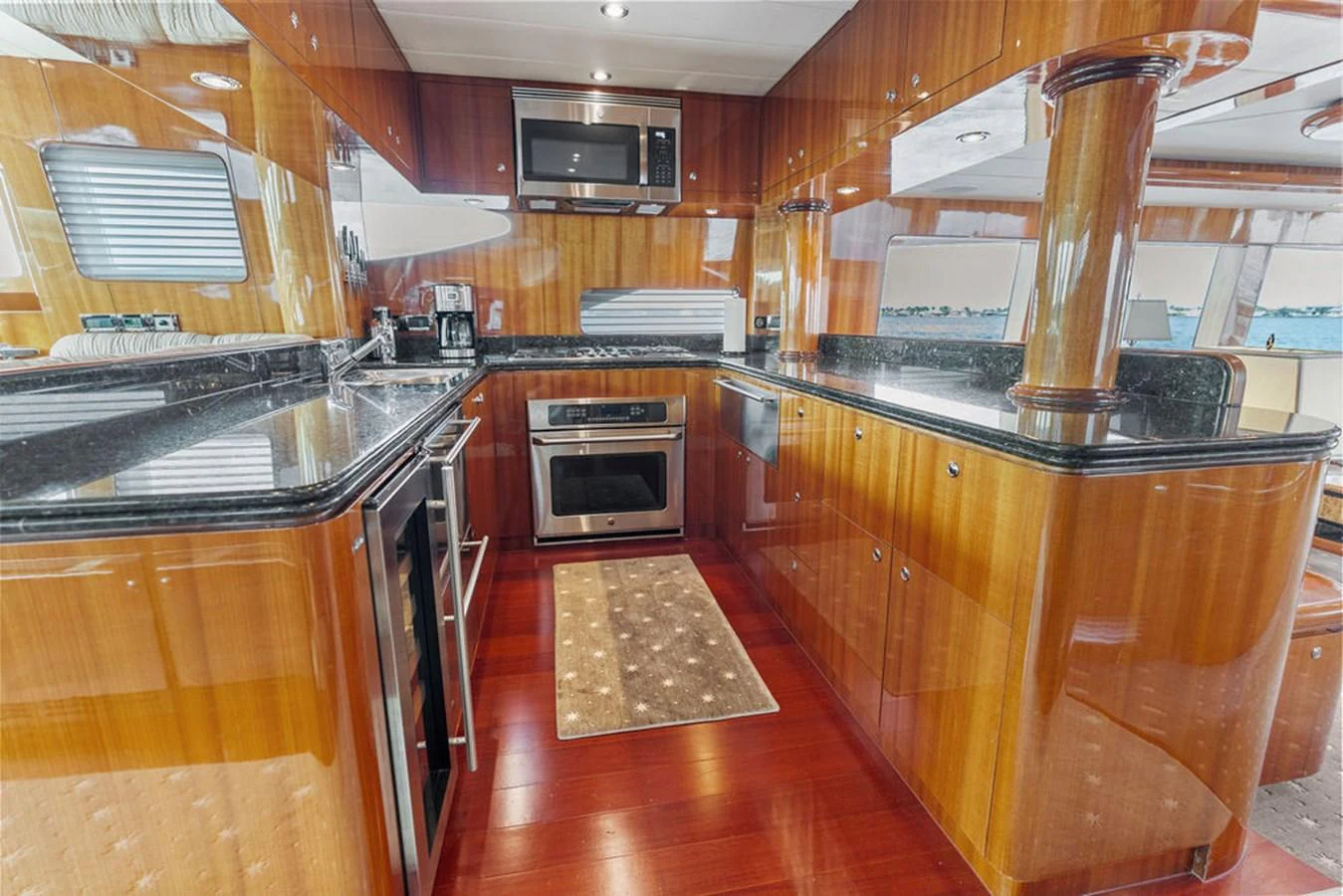 The yacht's galley features polished wood cabinetry, modern appliances, and a sleek countertop. aboard BABE Yacht for Sale