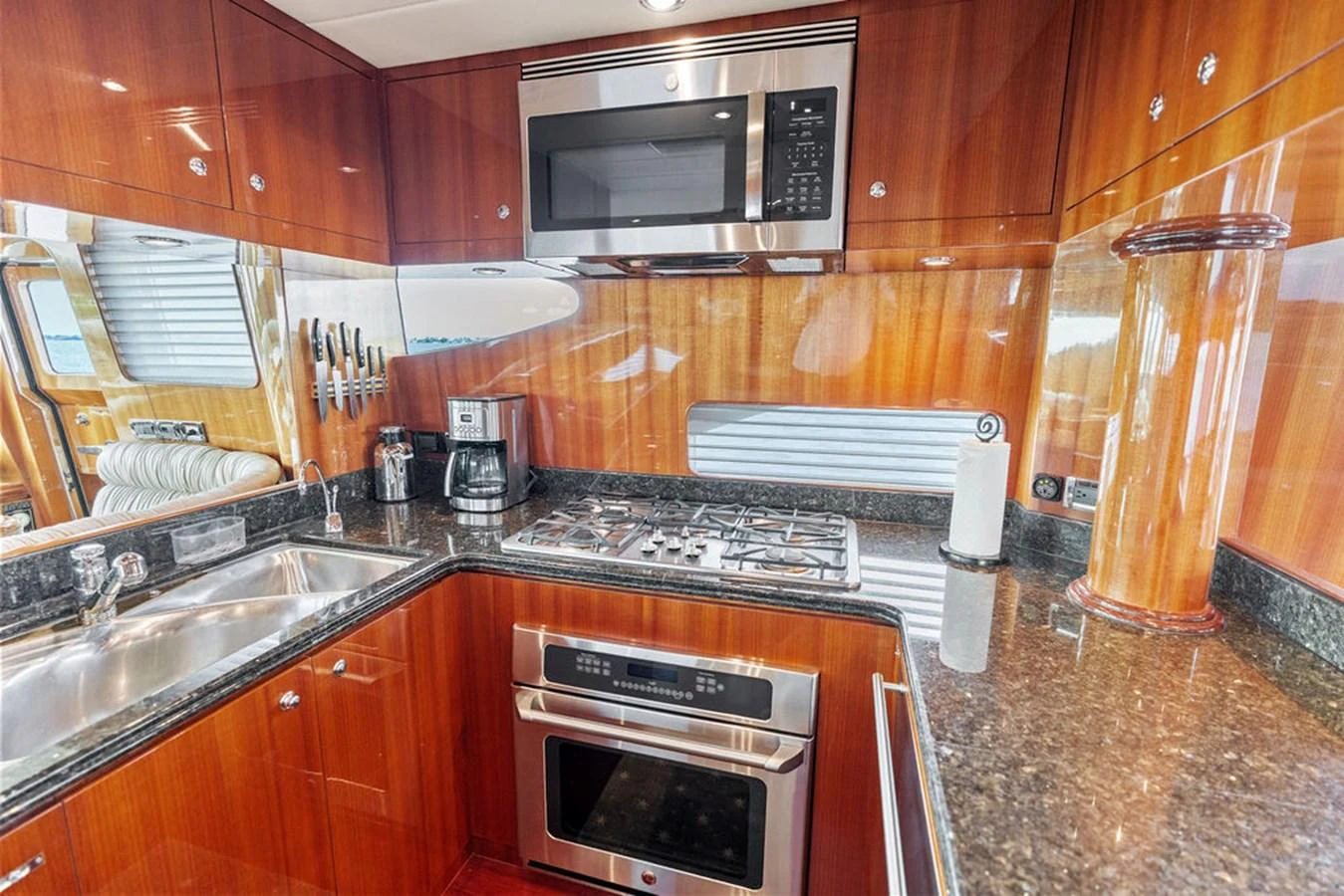 The galley features modern appliances and rich wood cabinetry, creating a warm and functional space for meal preparation. aboard BABE Yacht for Sale