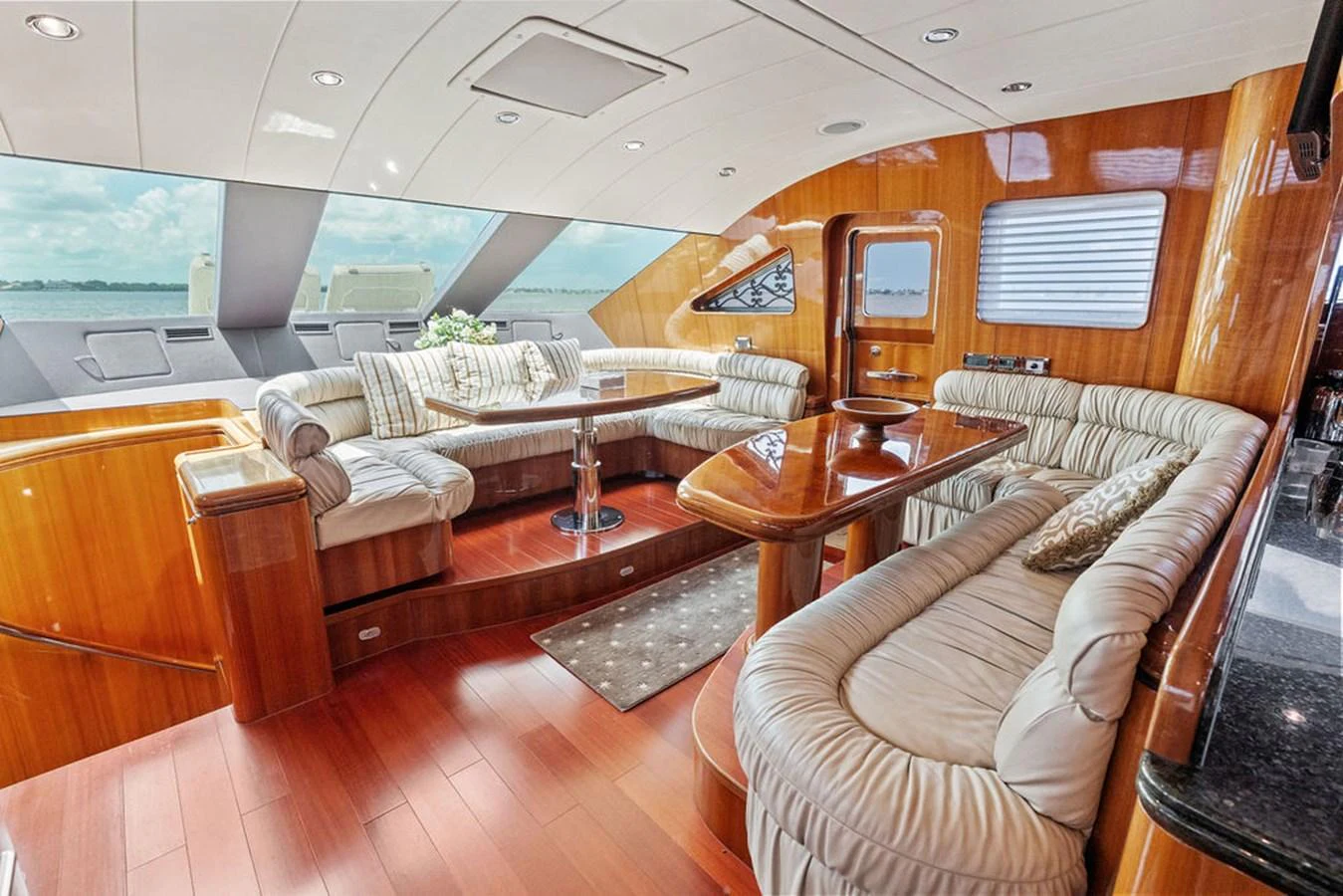 The salon features plush seating and elegant wood finishes, offering a luxurious space for relaxation and socializing. aboard BABE Yacht for Sale