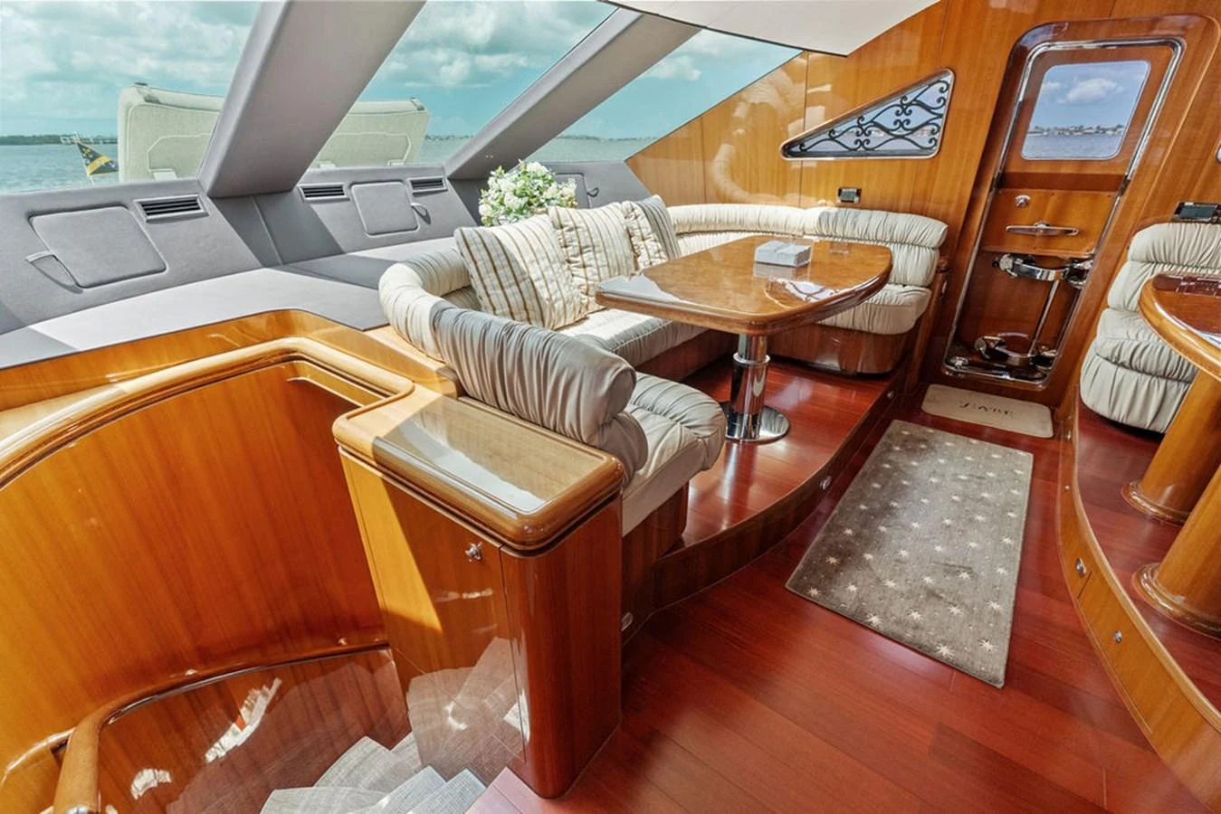 The salon features elegant wood finishes, plush seating, and ample natural light. aboard BABE Yacht for Sale