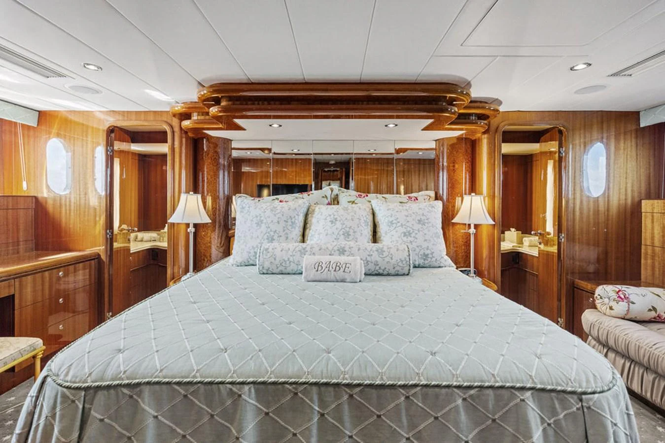 The master stateroom features a luxurious bed with elegant bedding and warm wood accents. aboard BABE Yacht for Sale